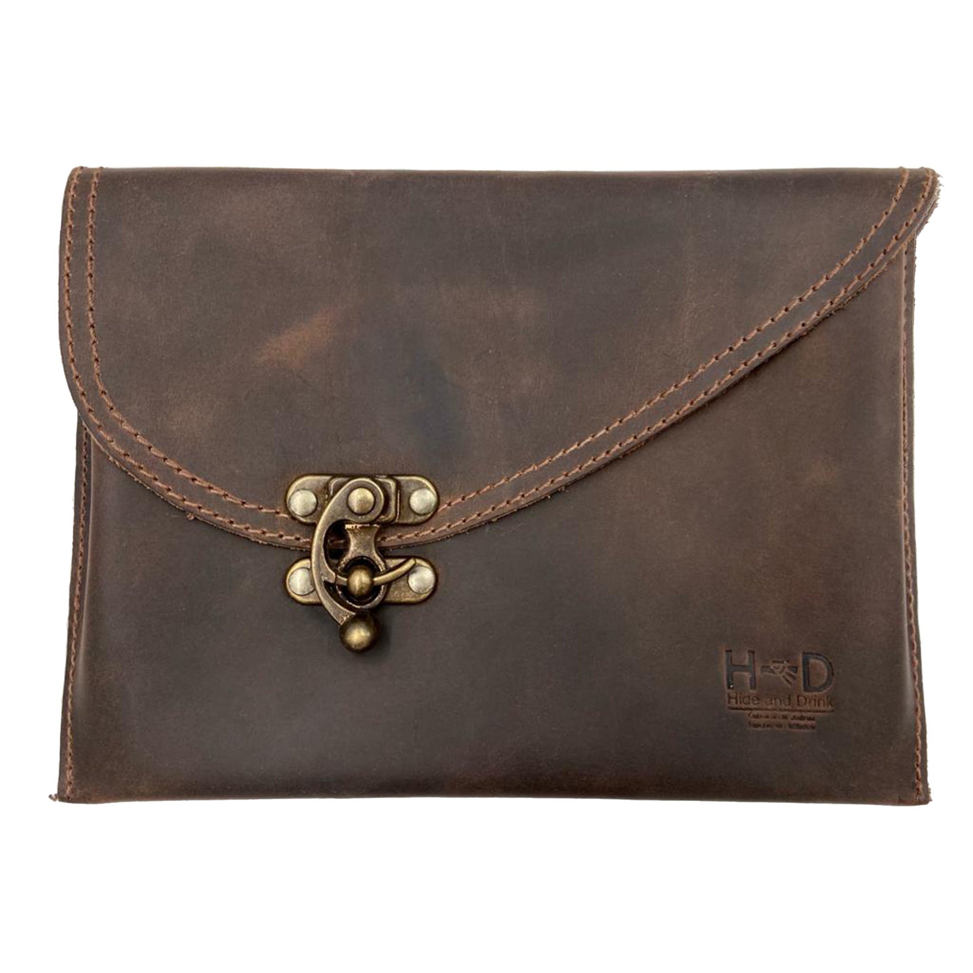 Showcasing the Petite Vintage Clutch Bag by Hide & Drink, this elegant handbag features a unique brass clasp and is made from full grain leather. Perfect for travel or as an evening bag, it's a stylish choice for those who value artisan craftsmanship, handmade in La Antigua Guatemala & Oaxaca Mexico.