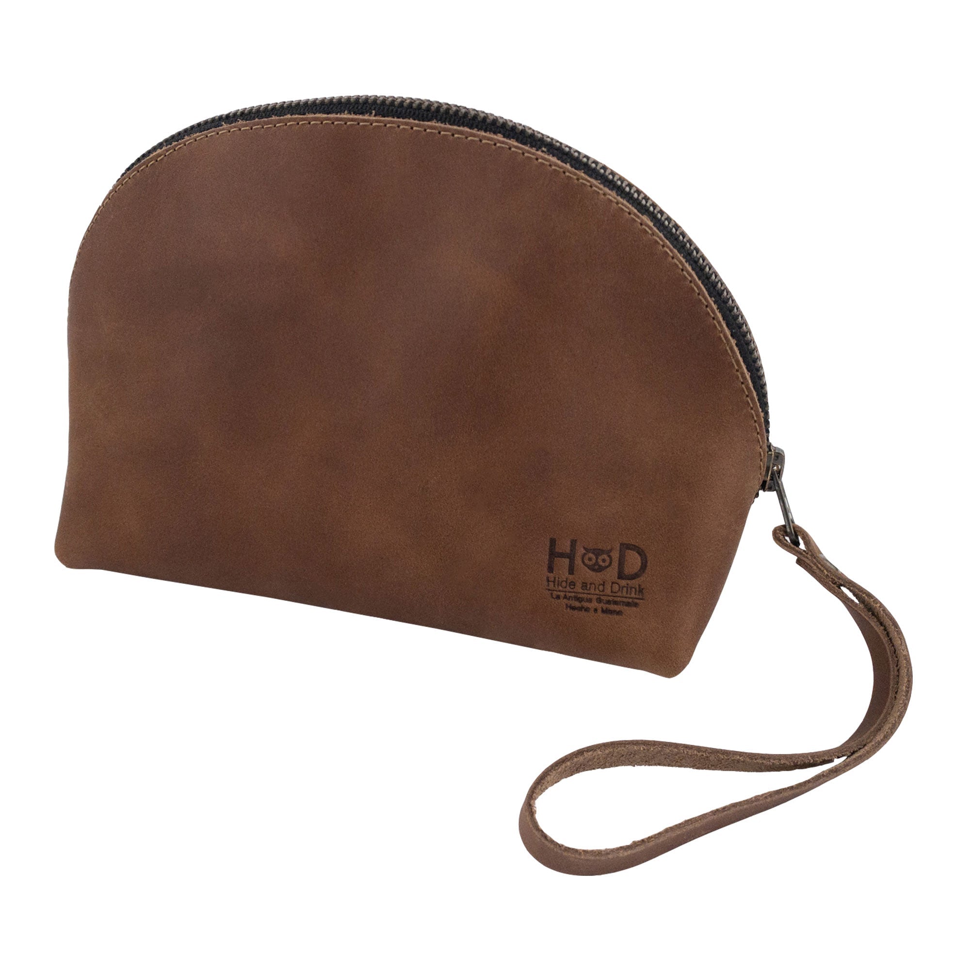The back view of the Accessory Pouch Organizer Hand Bag made by Hide & Drink, in premium brown leather. This Cosmetic Travel Organizer with Hand Strap for Women doubles as a Makeup Bag and Classic Handbag, highlighting small batch production craftsmanship from La Antigua Guatemala & Oaxaca Mexico.