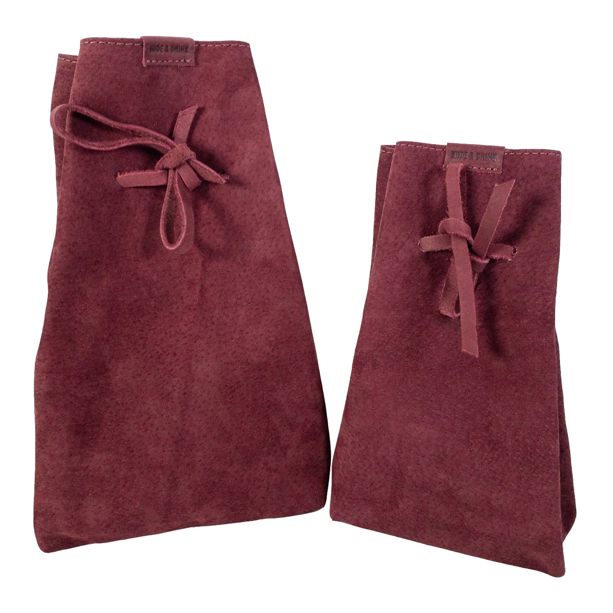 Hide & Drink's Drawstring Sack (2 pack) displayed with various items, emphasizing its multipurpose functionality and stylish aesthetic. Drawstring Sack (2 pack) Handmade from Sheepskin and Full Grain Leather, StockyardX, Small Batch Production, Hand Cut, Hand Sewn, Fire Branded, Artisan, Handmade in La Antigua Guatemala & Oaxaca Mexico.
