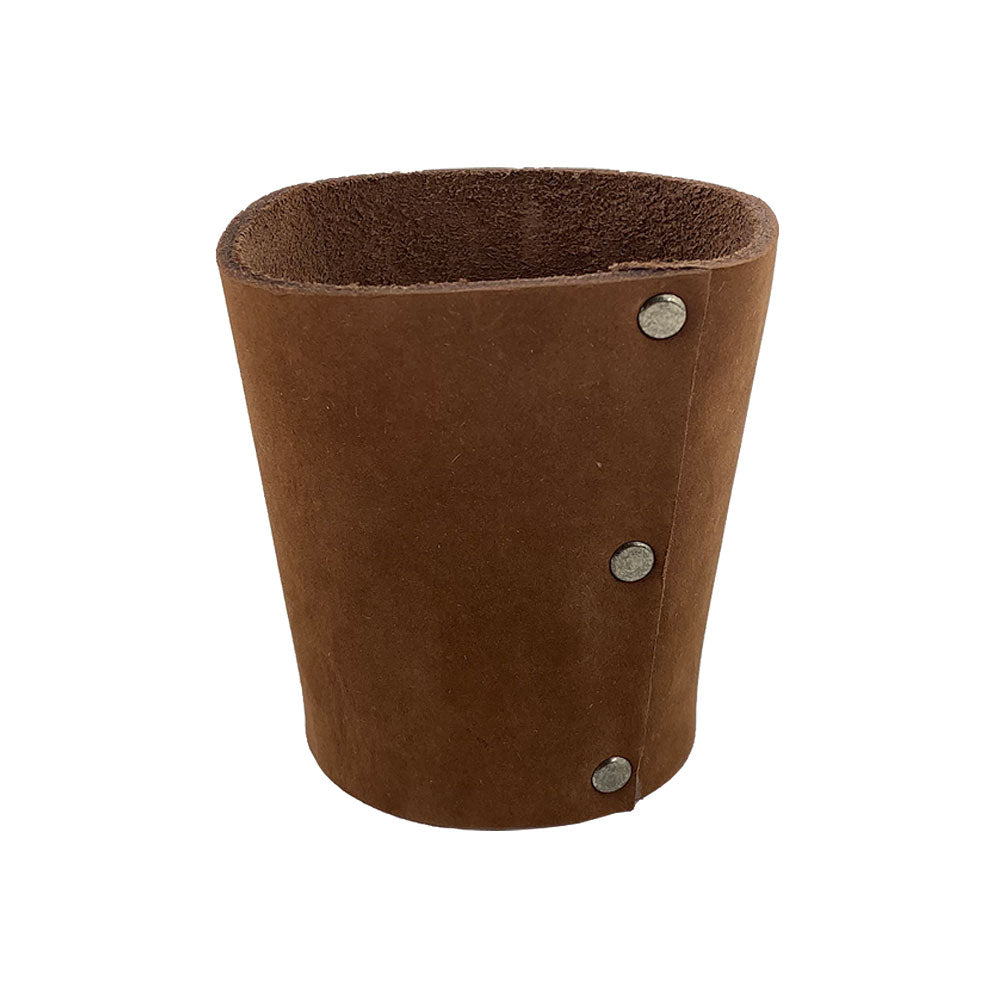 Side view of the Hide & Drink brown leather Pint Sleeve, featuring its sturdy construction designed for insulation against temperature changes. This classic piece is adorned with brass metal rivets and represents small batch artisan quality from La Antigua Guatemala & Oaxaca Mexico.