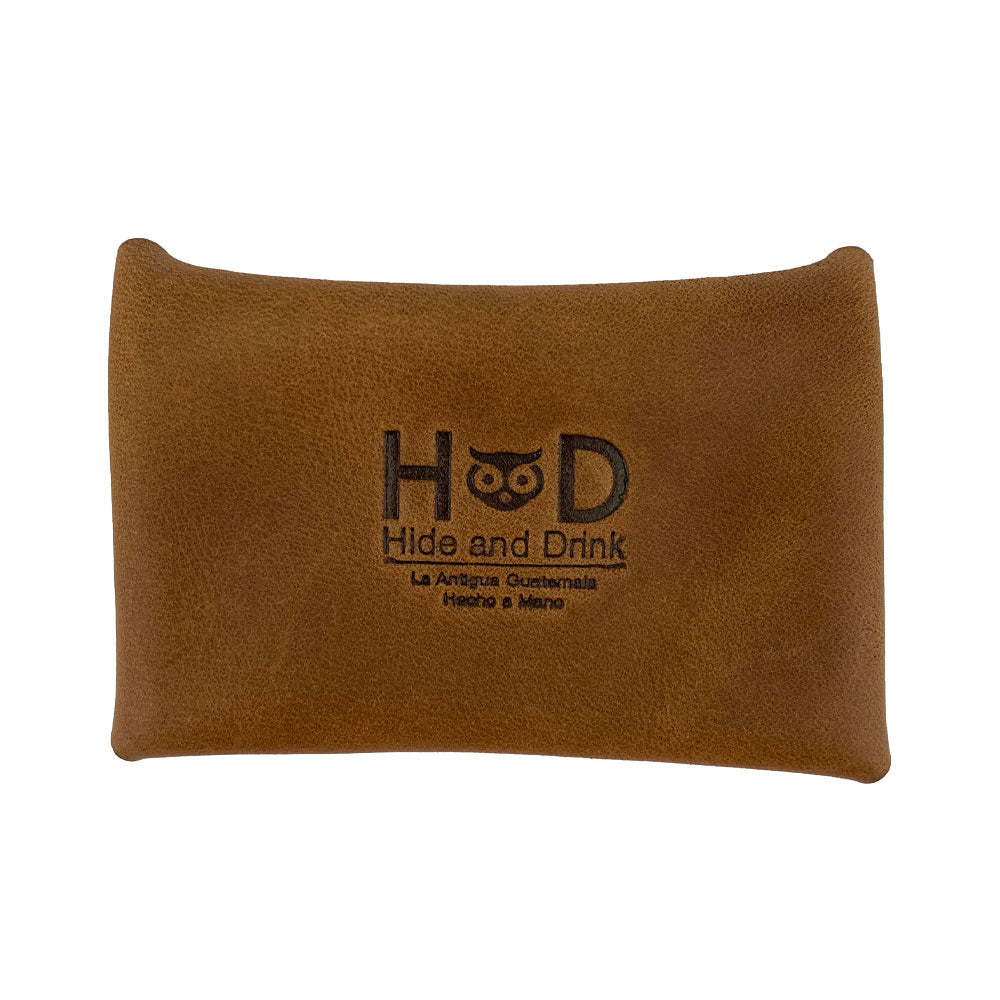 The brown Hide & Drink Envelope Coin Case featuring a branded logo, showcasing quality craftsmanship. Handcrafted from full grain leather, this rustic leather case is produced in La Antigua Guatemala & Oaxaca Mexico.