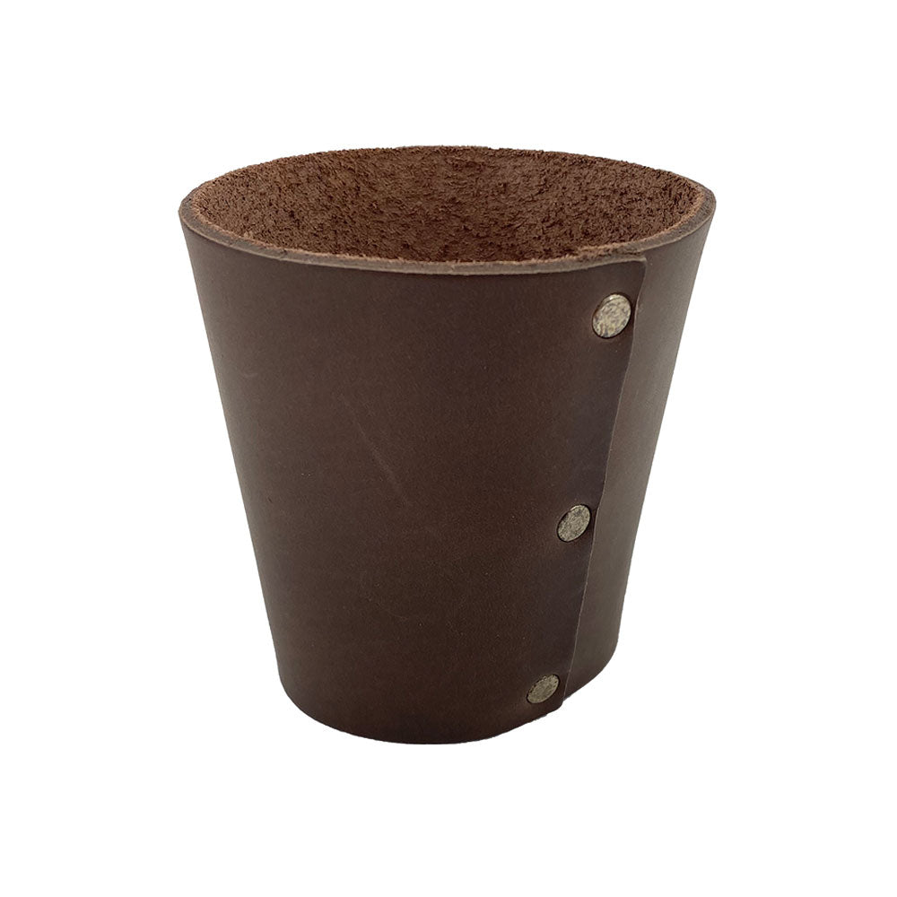 Another perspective of the Hide & Drink Pint Sleeve showcasing its small batch production and sturdy durable leather design, perfect for maintaining beverage temperature. The brass metal rivets add a classic touch, while the fire branded logo represents artisan quality, made in La Antigua Guatemala & Oaxaca Mexico.