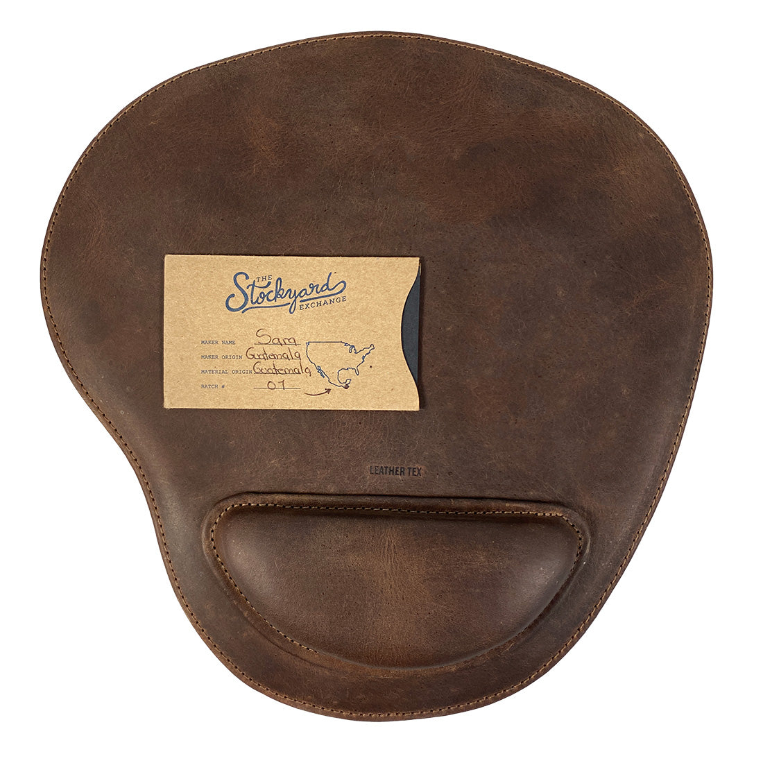 The Rustic Oval Shape Mousepad by LeatherTex, with a personalization card, showcases its artisan quality and unique production process. This full grain leather mousepad serves as a perfect addition for computers, laptops, and Macs, featuring an anti-slip, durable stitched design. Handmade in La Antigua Guatemala & Oaxaca Mexico.