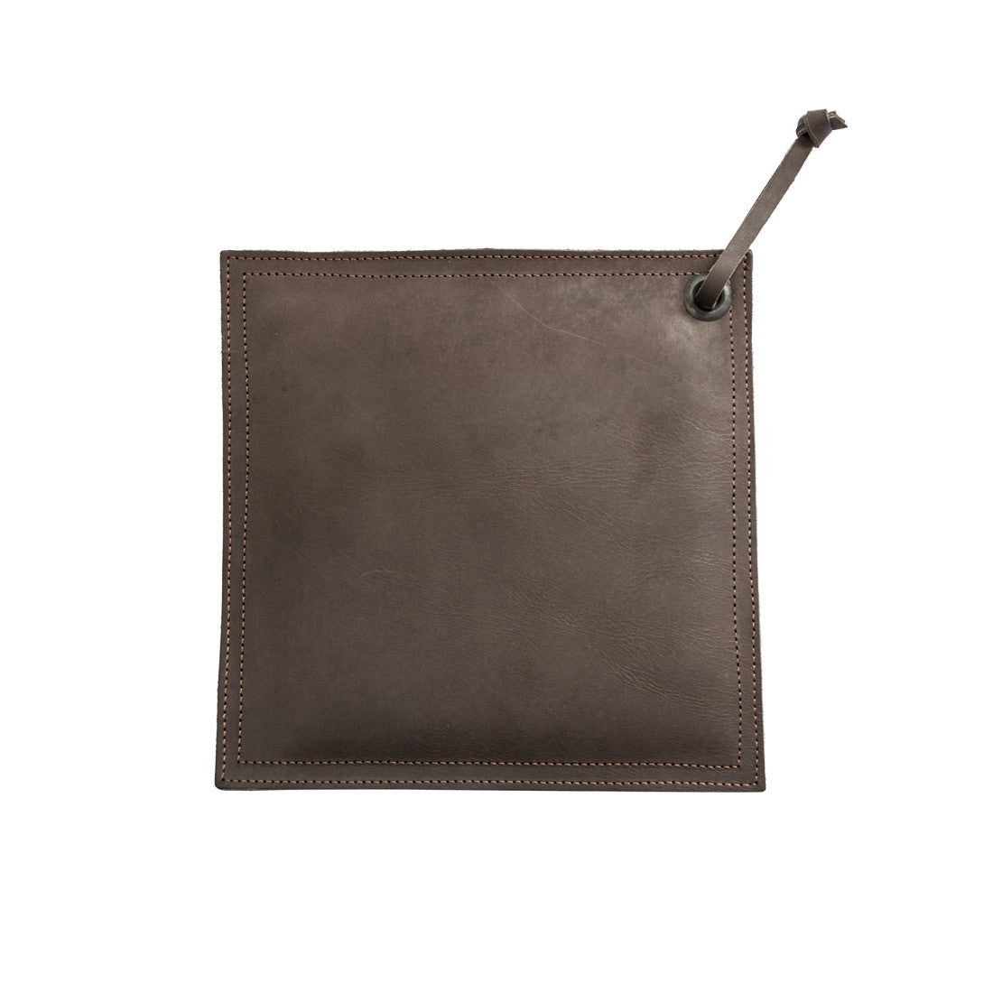 Hide & Drink Pot Pad displayed next to a cast iron skillet, emphasizing its craftsmanship and functionality as a rustic hot pot pad.