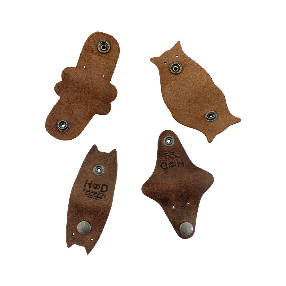 Furry Friends Cord Keeper (4-Pack) featuring unique animal designs, crafted from full grain leather by Hide & Drink to keep your cords neat and tidy. Furry Friends 4-Pack Cord Keeper (Cord Clam), Full Grain Leather, StockyardX, Small Batch Production, Hand Cut, Hand Sewn, Fire Branded, Artisan, Handmade in La Antigua Guatemala & Oaxaca Mexico.