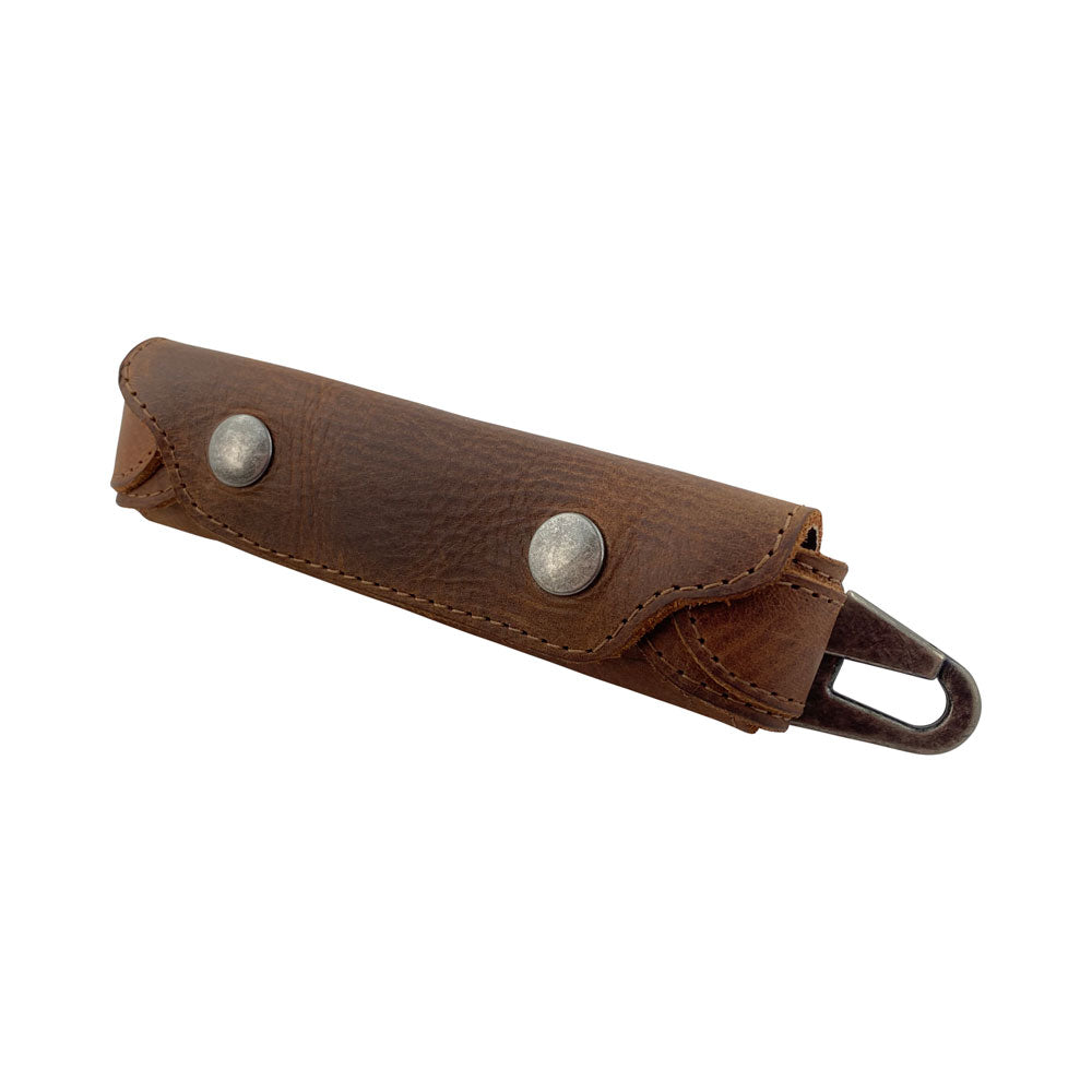 Harmonica Case from Hide & Drink displayed at an angle, highlighting its vintage style. Made for musicians, this full grain leather protector is hand cut and hand sewn, reflecting the quality of small batch production. Artisan-made in La Antigua Guatemala, offering a stylish solution for harmonica storage.
