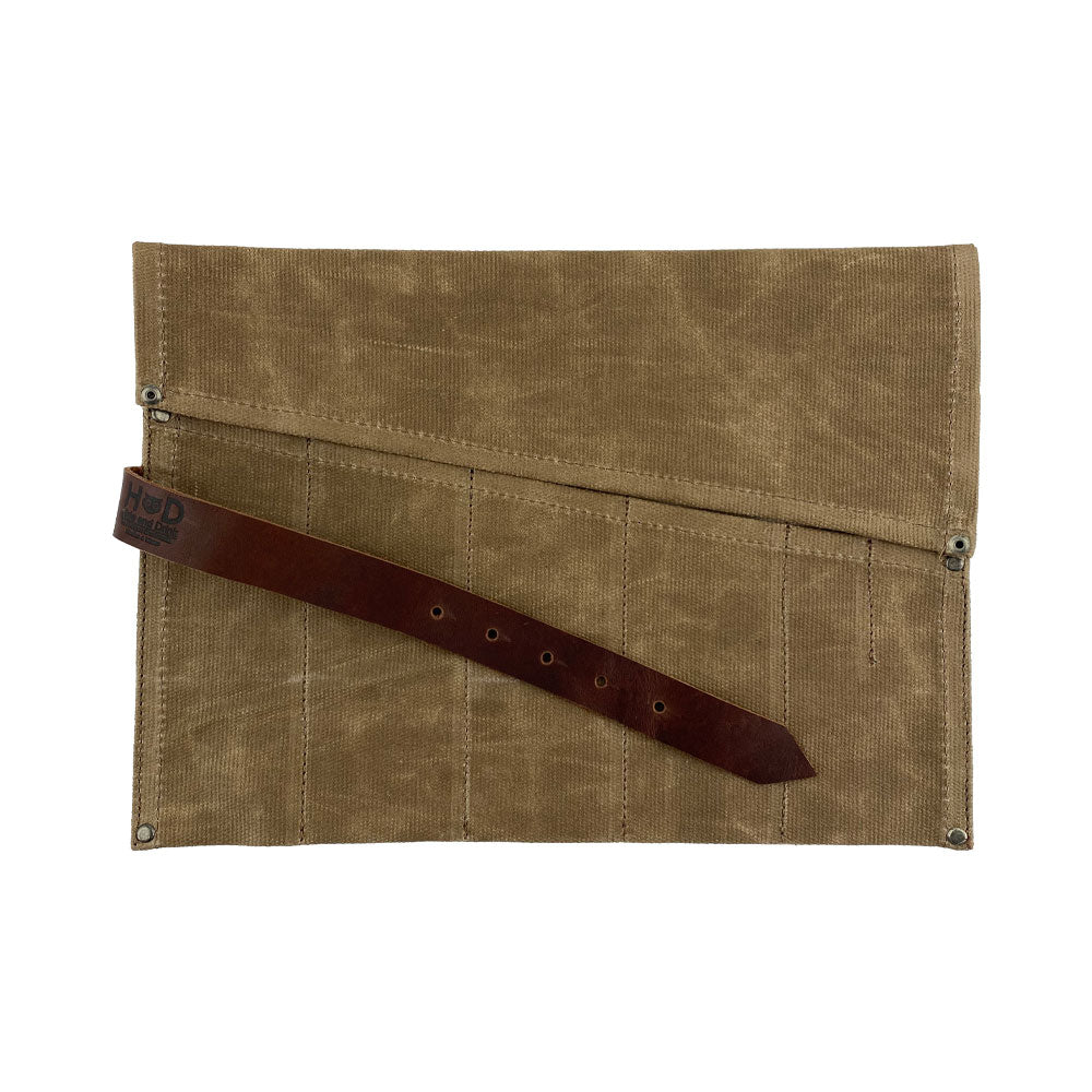 The Large Tool Roll from Hide & Drink showcasing its artisan detail. This Portable Carry-On Pouch provides 6 slots for woodworking tools organization, designed for convenience. Crafted from waxed canvas and full grain leather variations, this artisan item exemplifies hand-cut, hand-sewn craftsmanship made in La Antigua Guatemala & Oaxaca Mexico.