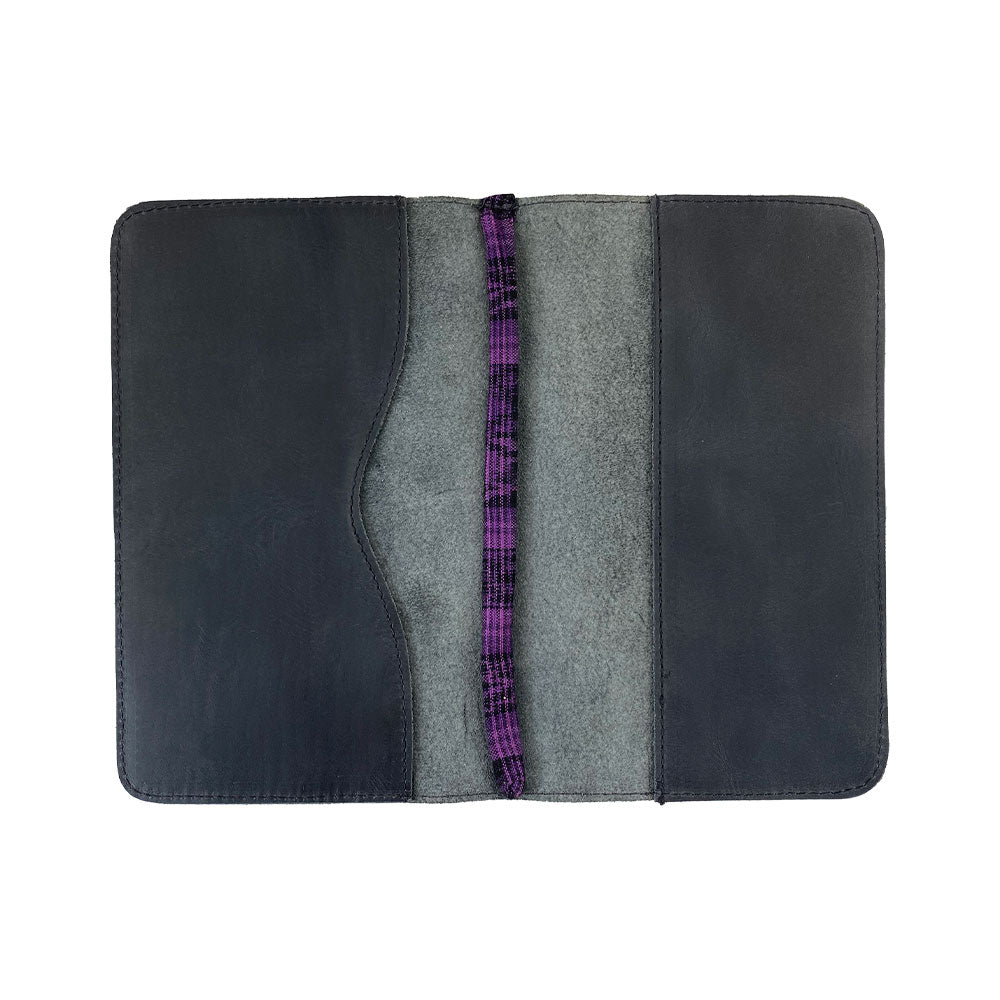 Open interior of a black Journal Cover for Moleskine Cahier L (5 x 8.25 in.) by Hide & Drink, featuring a purple textile bookmark. This refillable journal cover is ideal for your large size (5 x 8.25 in.) notebook, reflecting handmade artisan qualities.