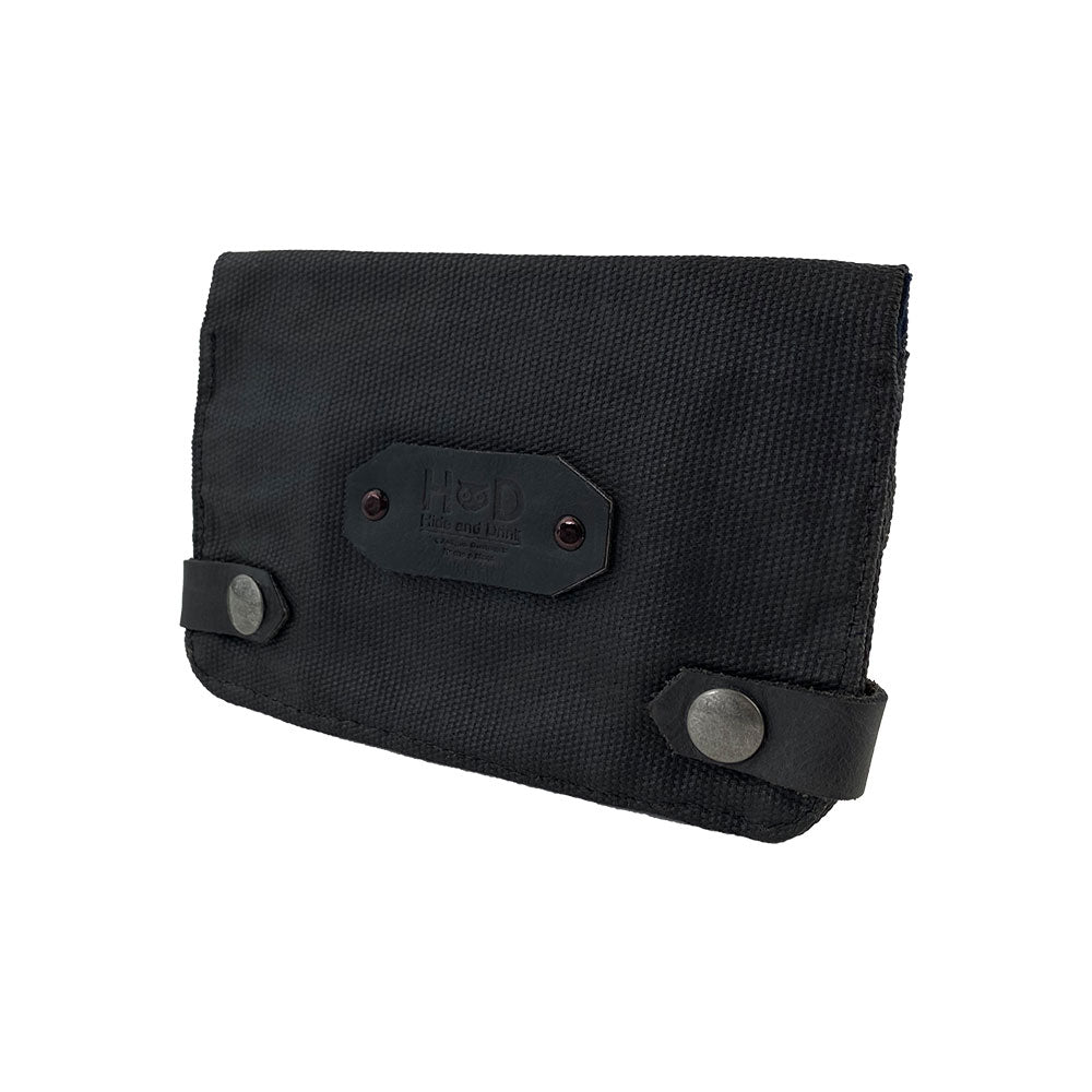 Side view of the black Hide & Drink Tobacco Pouch Waxed Canvas focusing on its sturdy design. This classic storage option is perfect for organizing tobacco and field notes, combining durability with artisan craftsmanship.
