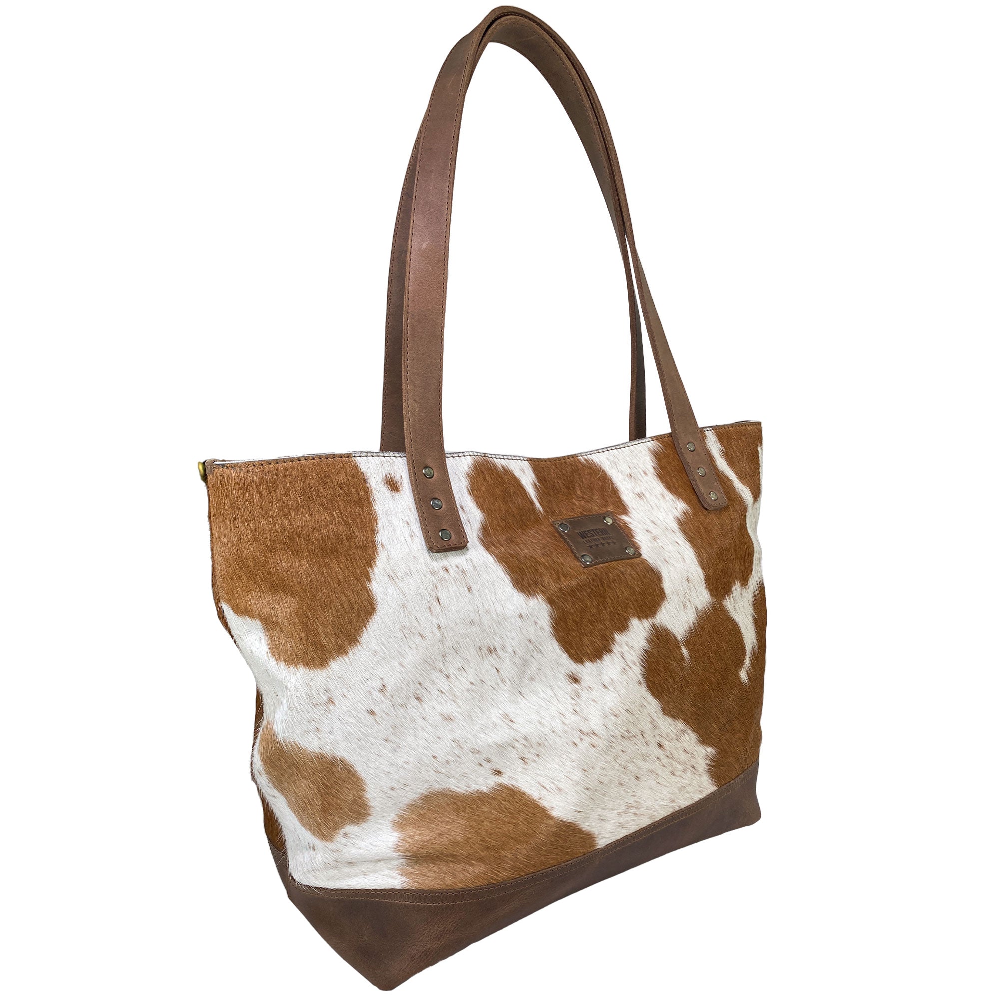 Western Leather Works Formal Tote Bag, designed in Hair on Hide Full Grain Leather with a striking brown and white spotted pattern. This bag is both spacious and versatile, seamlessly blending functionality with an elegant cowboy aesthetic. Handmade with precision, featuring a plaid cotton interior lining. Artisan, handmade in La Antigua Guatemala & Oaxaca Mexico.
