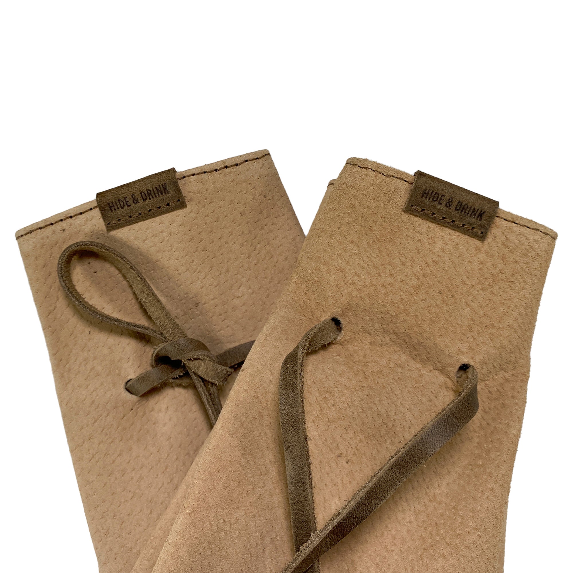 Detail view of Hide & Drink's Drawstring Sack (2 pack) featuring the leather's craftsmanship and brand tag, showcasing its artisan quality. Drawstring Sack (2 pack) Handmade from Sheepskin and Full Grain Leather, StockyardX, Small Batch Production, Hand Cut, Hand Sewn, Fire Branded, Artisan, Handmade in La Antigua Guatemala & Oaxaca Mexico.