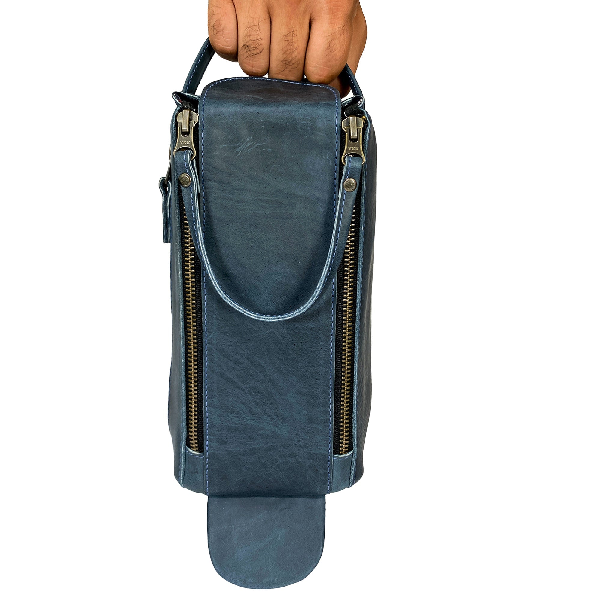 Someone holding the blue Hide & Drink Toiletry Bag, highlighting its compact design. This Full Grain Leather Toiletry Bag is a practical Hand Bag and Dopp Kit Organizer for travel. StockyardX, Handmade, S.