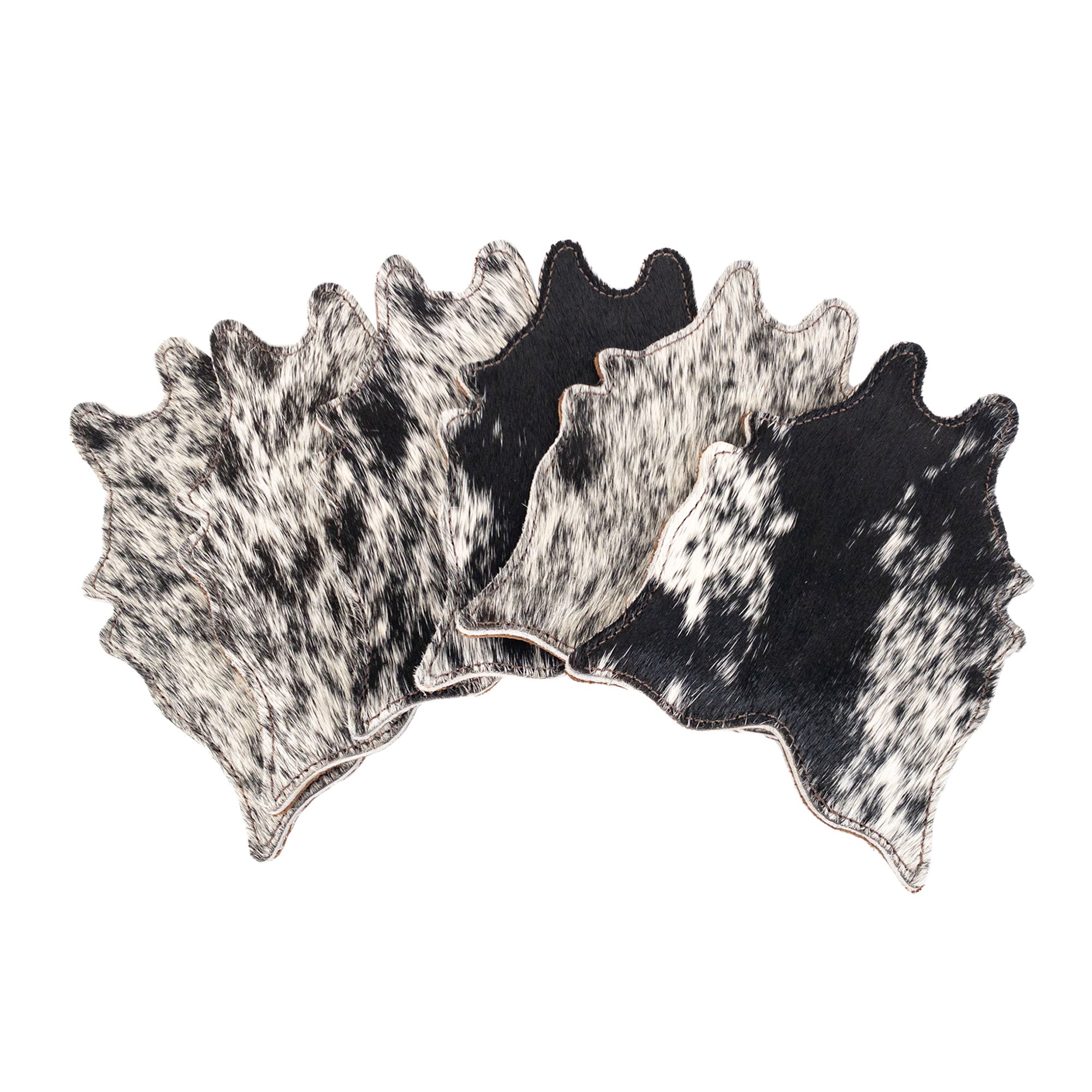 A collection of 4 black and white Cowhide Shape Set of 6 Coasters from Western Leather Works. Made from Hair On Hide Full Grain Leather, these handcrafted coasters are perfect for drinks and represent artisan craftsmanship from La Antigua Guatemala & Oaxaca Mexico.