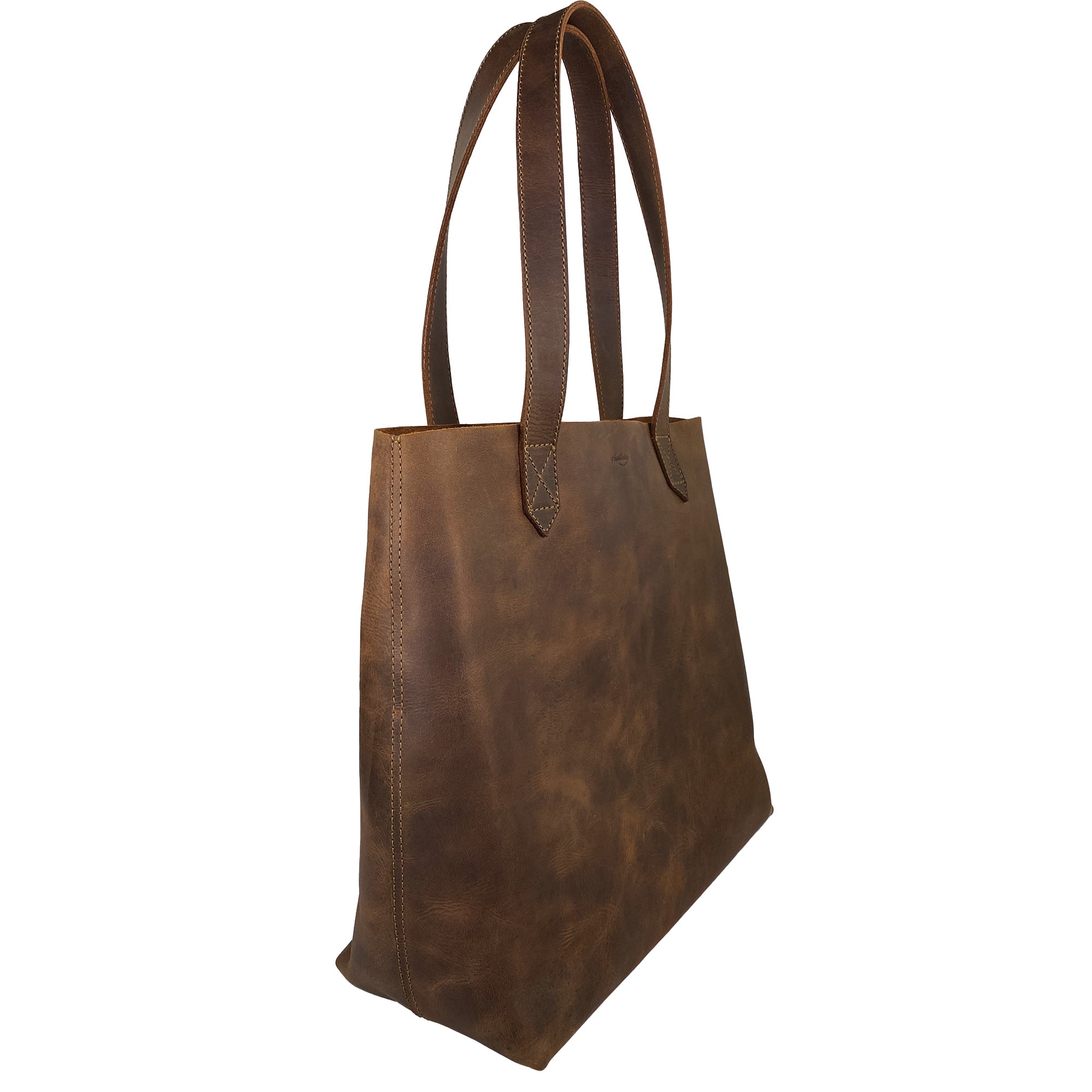 Side view of Heather's Classic Tote Bag highlighting the unique texture of full grain leather. This spacious handbag is perfect for travel and shopping, reflecting the artisanal skills of being hand cut and hand sewn.