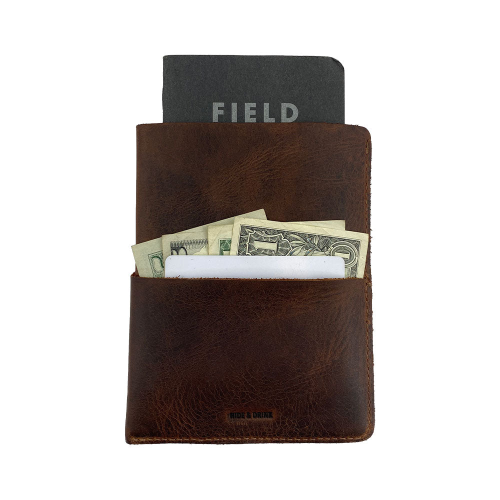 Hide & Drink Multi-Tool Pocket Sleeve with cash and a notebook inside, showcasing its utility as a Rustic Multitool Pocket Pouch, Classic Multipurpose Bag, and Compact Organizer. Created from high-quality Full Grain Leather, and crafted through small batch production by artisans in La Antigua Guatemala & Oaxaca Mexico.