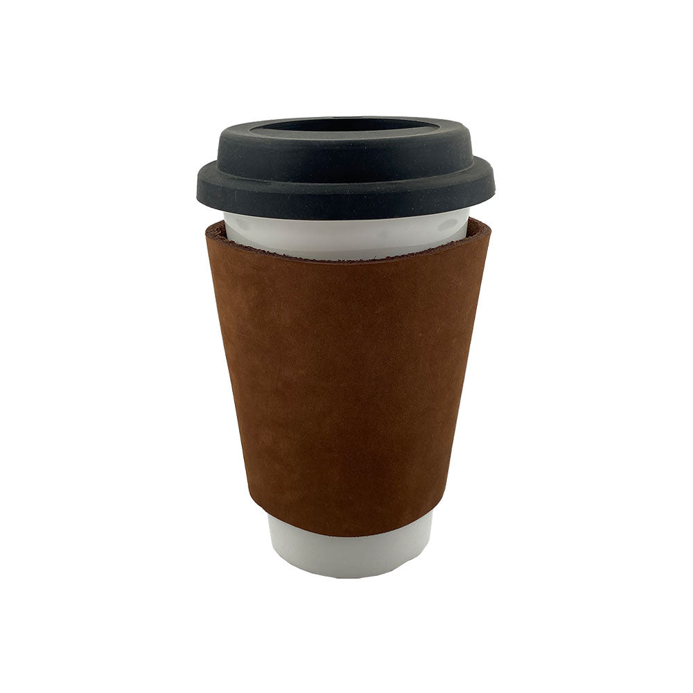 The brown leather Pint Sleeve by Hide & Drink fits perfectly around a coffee cup, illustrating its practical and stylish design. This sturdy, durable leather offers temperature control and is suitable for gifts, crafted in small batches in La Antigua Guatemala & Oaxaca Mexico.