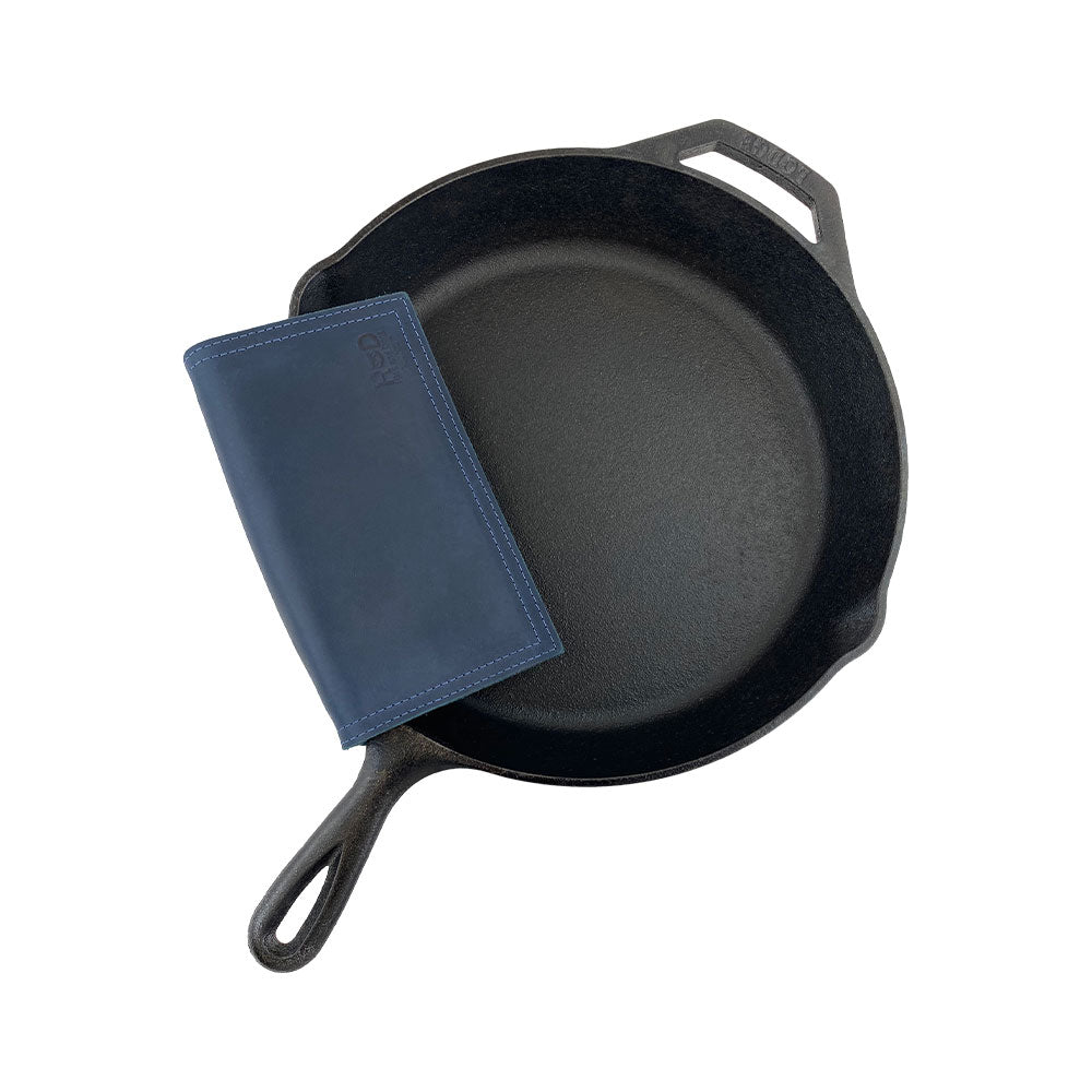 Hide & Drink Pot Pad displayed next to cookware, showcasing its utility as a pot holder. Crafted from premium leather, it is both stylish and effective.