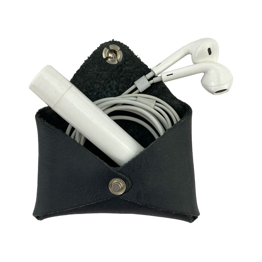 Hide & Drink Envelope Coin Case holding earphones, showing its multifunctionality. Crafted from high-quality full grain leather, this rustic leather product embodies small batch production and artisan techniques in La Antigua Guatemala & Oaxaca Mexico.