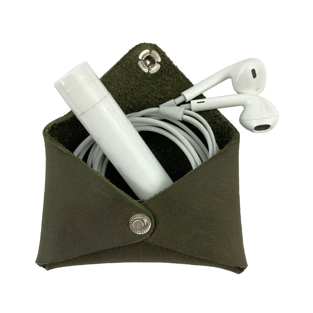 Hide & Drink Envelope Coin Case with earphones inside, demonstrating its multifunctional design. Crafted from full grain leather, this rustic leather product represents artisan skills and small batch production in La Antigua Guatemala & Oaxaca Mexico.
