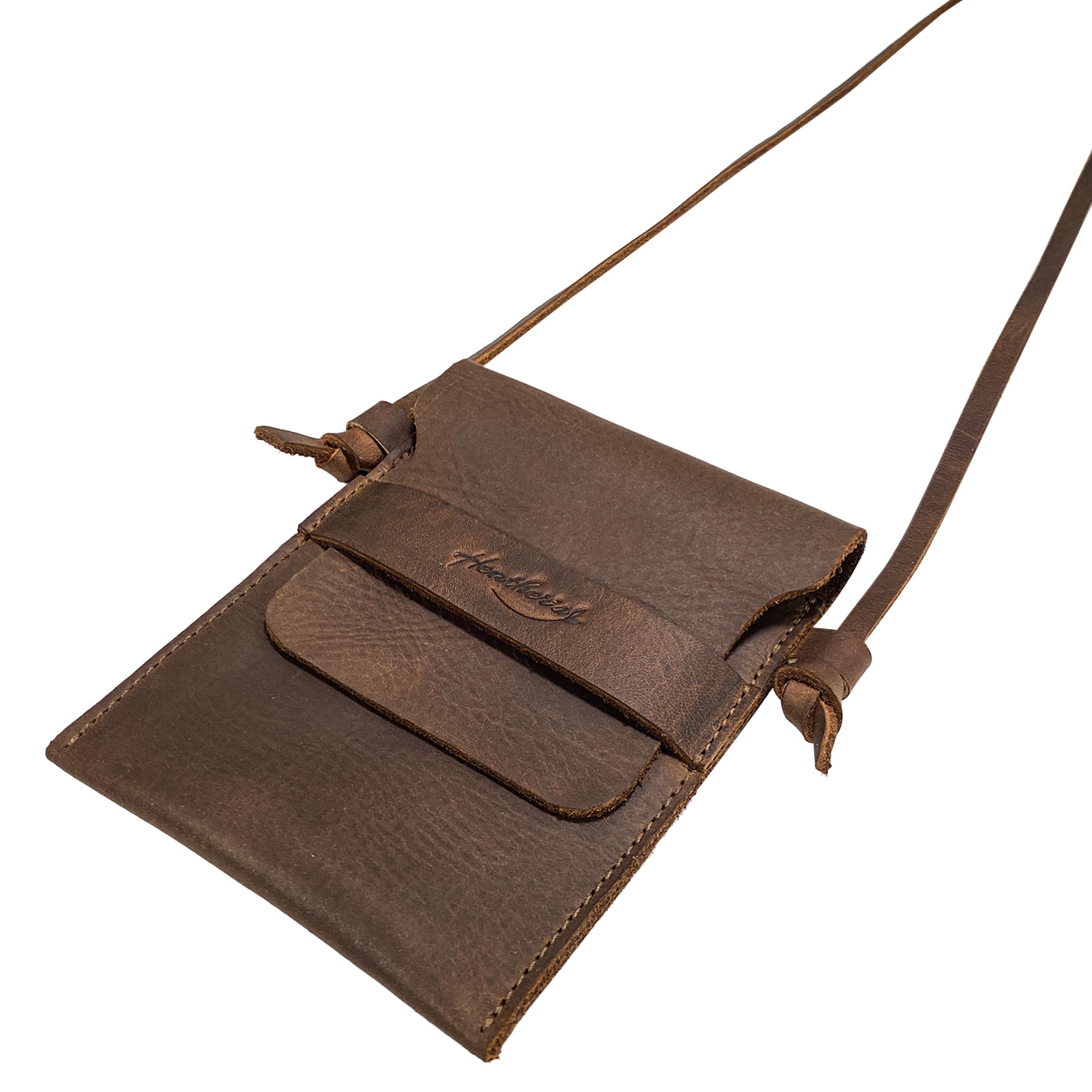 Close-up of the front flap of the Mini Travel Bag by Heather's highlighting the fine craftsmanship and leather texture. This Mini Travel Bag Handmade from Full Grain Leather is a classic organizer, coin pouch, and storage case for ID, credit cards, and cash. StockyardX, Small Batch Production, Hand Cut, Hand Sewn, Fire Branded, Artisan, Handmade in La Antigua Guatemala & Oaxaca Mexico.