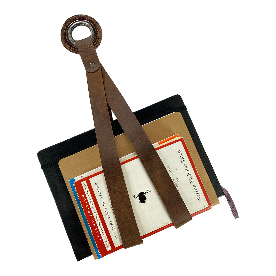 A Book Wall Hanger by Leather At Home featuring full grain leather, perfect for organizing reading materials like books and magazines. This rustic book hanger reflects artisan skills and meticulous attention to detail through small batch production and is handmade in La Antigua Guatemala & Oaxaca Mexico.