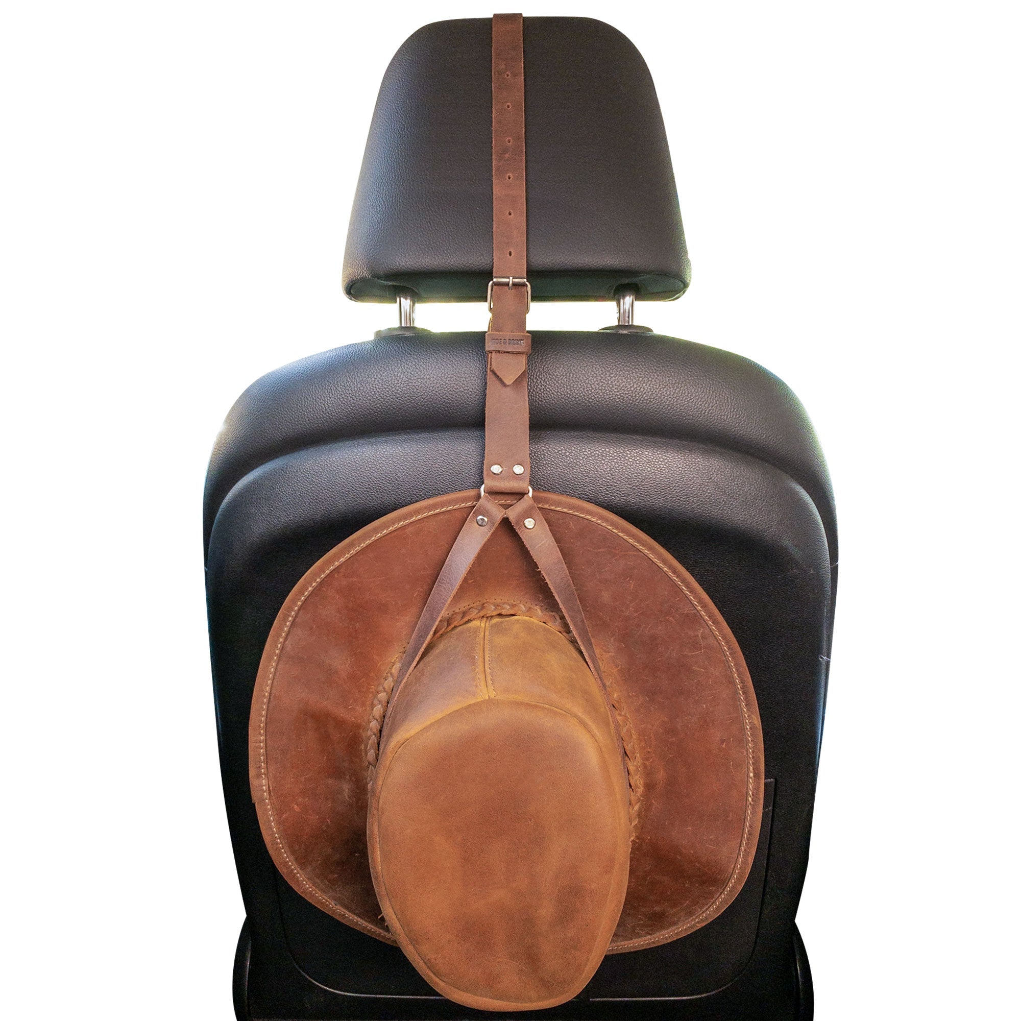 Hat Hanger by Hide & Drink displayed on a car seat, showcasing its adjustable strap and excellent organization capability. Made from full grain leather, this travel accessory is designed for durability and minimalist aesthetics, emphasizing artisan craftsmanship in La Antigua Guatemala & Oaxaca Mexico.