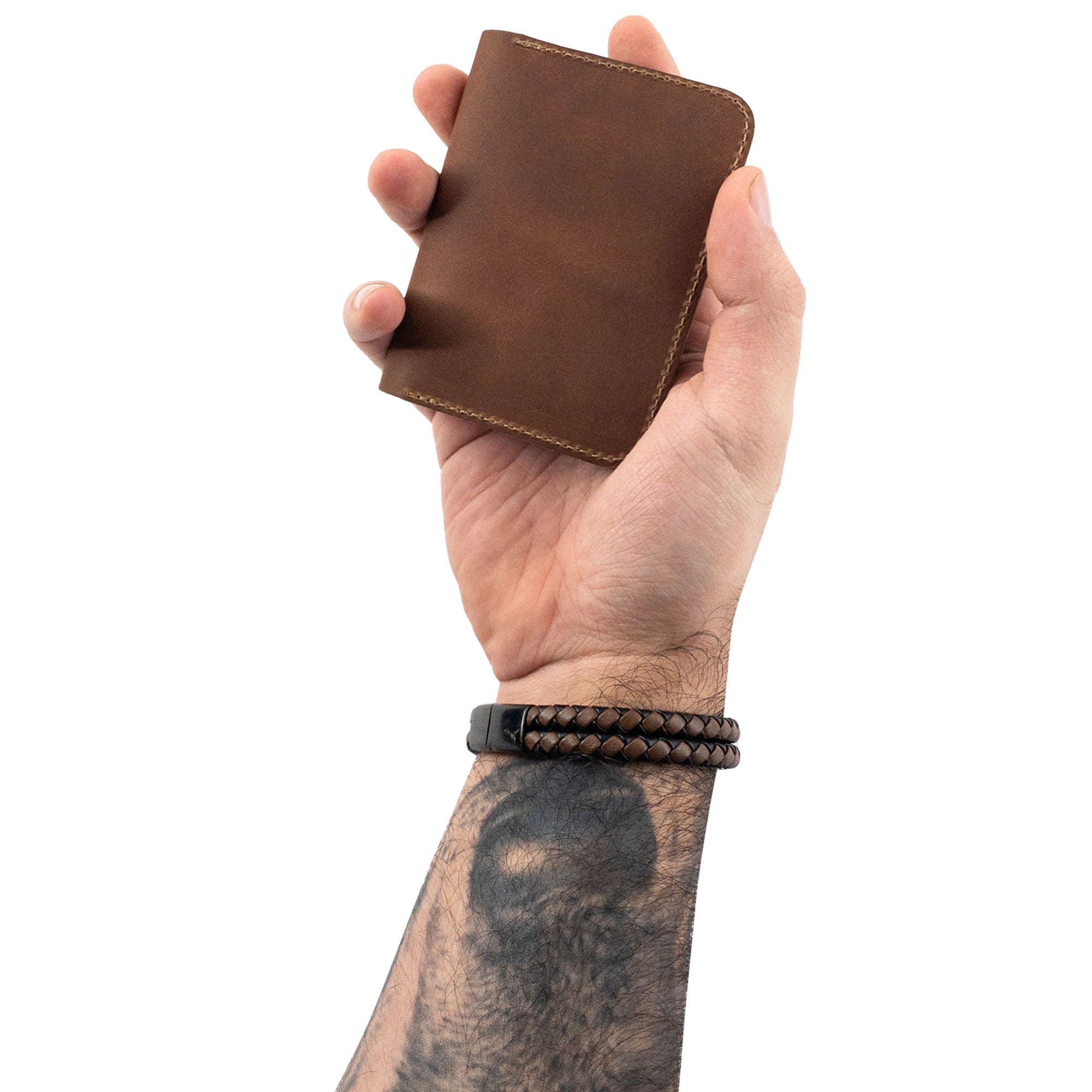 A held brown Bi-Fold Card Wallet Diagonal by Hide & Drink illustrating its compact design, perfect for organization and made with artisan quality full grain leather.