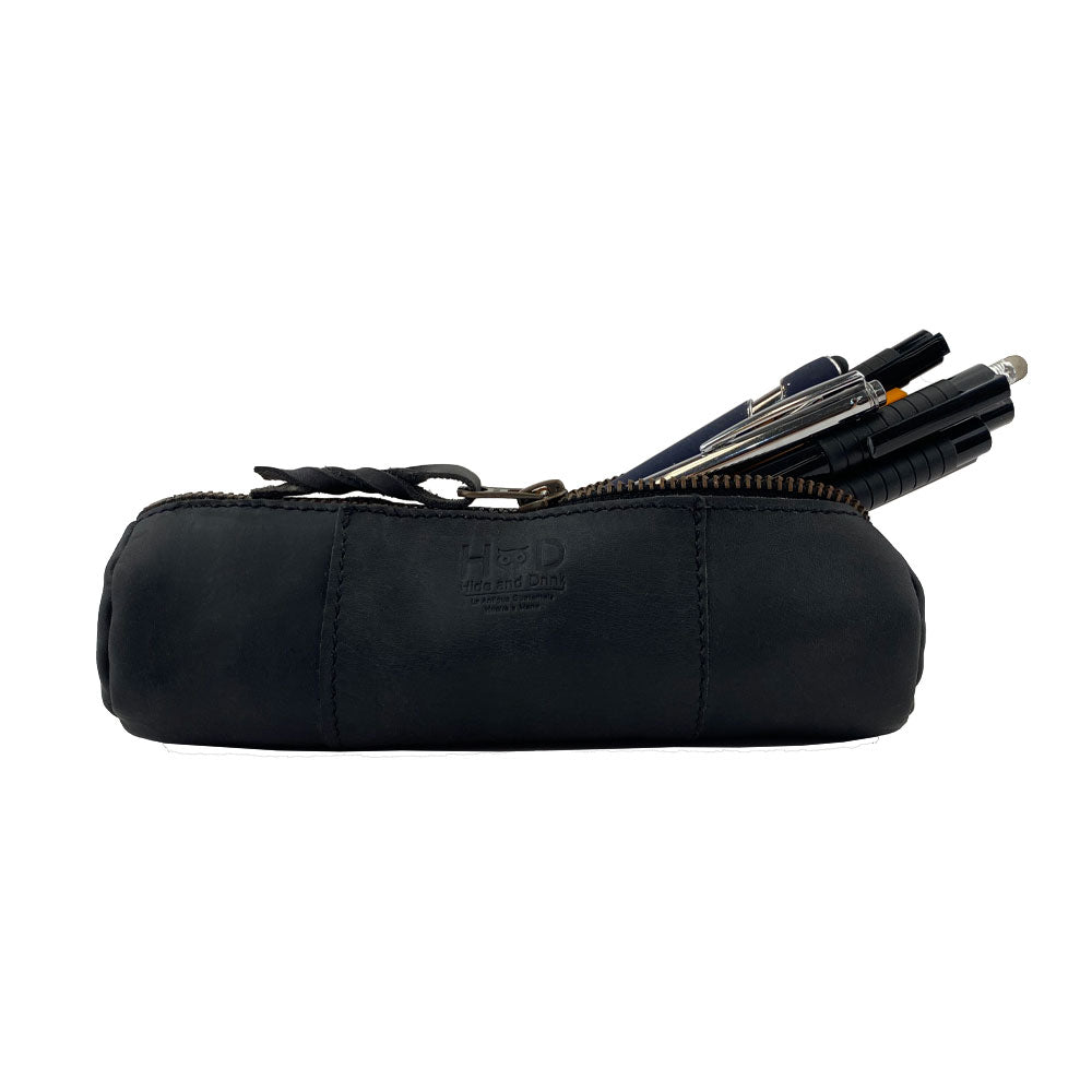 Utility Cylinder Case by Hide & Drink in black leather, designed for personal items or office supplies. This small batch, artisan bag showcases the beauty of Full Grain Leather craftsmanship. Cylinder Case, Classic Bag, Handmade.