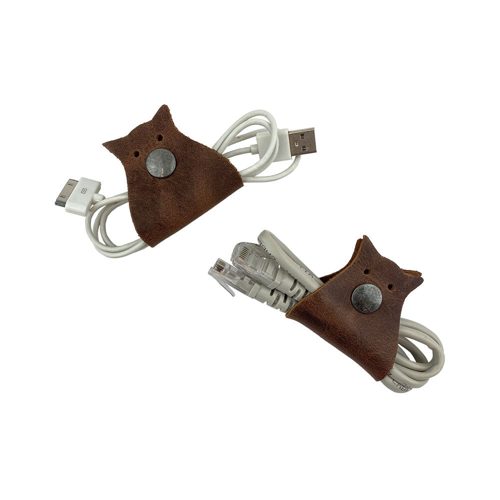 Owl Shaped Cord Keeper (2-Pack) by Hide & Drink featuring practical and stylish design for organizing cables, perfect for tech enthusiasts. Owl Shaped Cord Keeper (Cord Clam) 2-Pack. Full Grain Leather, StockyardX, Small Batch Production, Hand Cut, Hand Sewn, Fire Branded, Artisan, Handmade in La Antigua Guatemala & Oaxaca Mexico.
