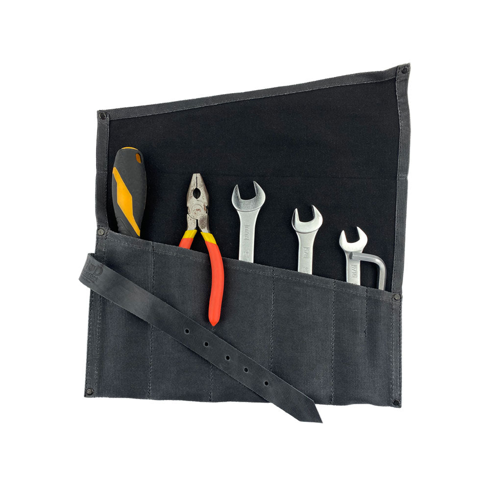 A detailed view of the Large Tool Roll by Hide & Drink, highlighting its organizational purpose. This Portable Carry-On Pouch contains 6 slots ideal for effective woodworking tools storage. Made from premium waxed canvas and full grain leather variations, this artisan product represents small batch production, hand cut and hand sewn in La Antigua Guatemala & Oaxaca Mexico.