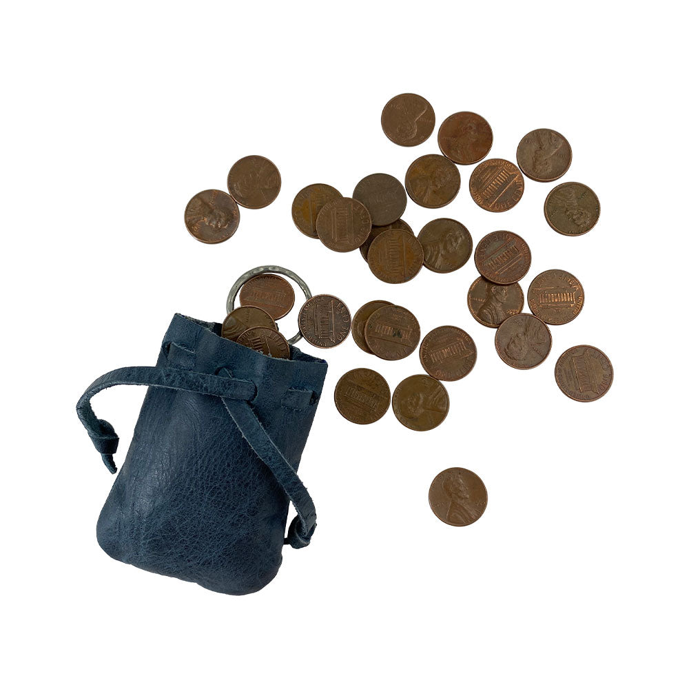 Coins spilling out of the Mini Medieval Pouch Keychain from Hide & Drink, a testament to its utility. This tiny bag with keyring, made from full grain leather, functions as an efficient coin organizer and symbolizes high-quality artisan craftsmanship from La Antigua Guatemala.