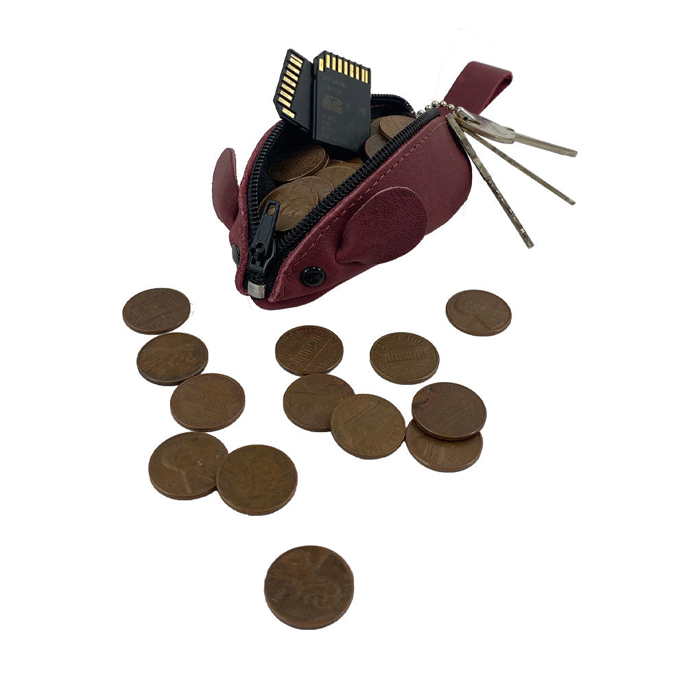 Hide & Drink's Mouse Coin Pouch amidst coins, showcasing its practical use. This Mouse-Shaped Coin Pouch is an essential change pouch made from premium full grain leather, perfect for keeping your coins in style.