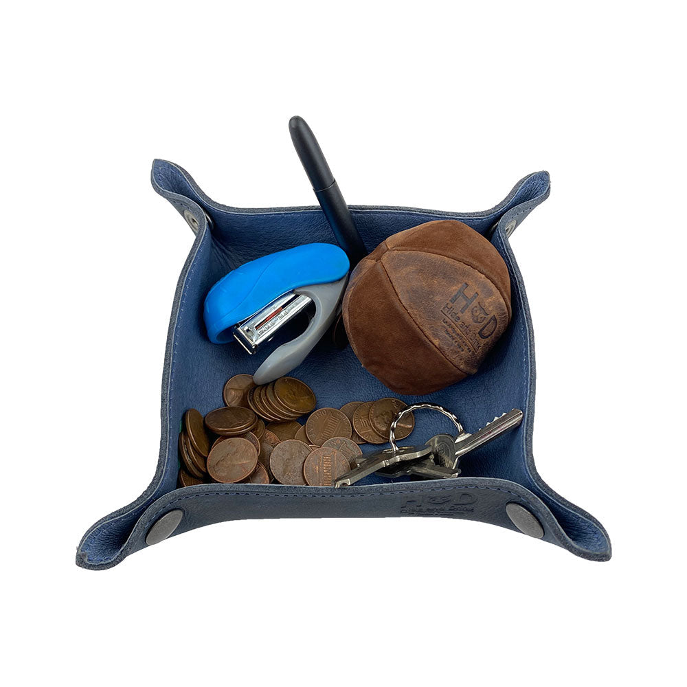 The Valet Tray with Sheep Skin by Hide & Drink filled with coins, keys, and a stapler, demonstrating its practicality in organizing everyday essentials. This artisanal tray personal items catchall is made from Full Grain Leather & Sheepskin and is perfect for maintaining order at home or on the go. A small batch production piece that's hand cut and sewn in La Antigua Guatemala & Oaxaca Mexico.
