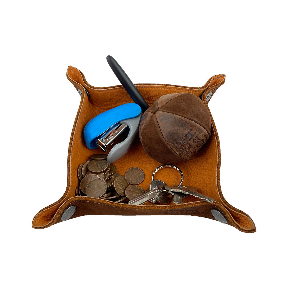 The Valet Tray with Sheep Skin by Hide & Drink in action, holding keys, change, and a stapler. This versatile tray is perfect for organizing personal items. Featuring Full Grain Leather & Sheepskin, it's both functional and stylish, showcasing artisan craftsmanship from La Antigua Guatemala & Oaxaca Mexico.