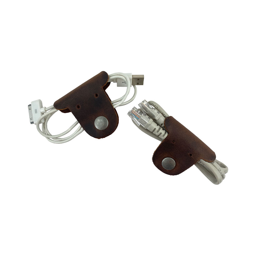 Two dark brown Dog Shaped Cord Keepers organizing USB cables, a fun way to keep your cords tidy by Hide & Drink, made from Full Grain Leather. Dog Shaped Cord Keeper (Cord Clam) 2-Pack, Full Grain Leather, StockyardX, Small Batch Production, Hand Cut, Hand Sewn, Fire Branded, Artisan, Handmade in La Antigua Guatemala & Oaxaca Mexico.