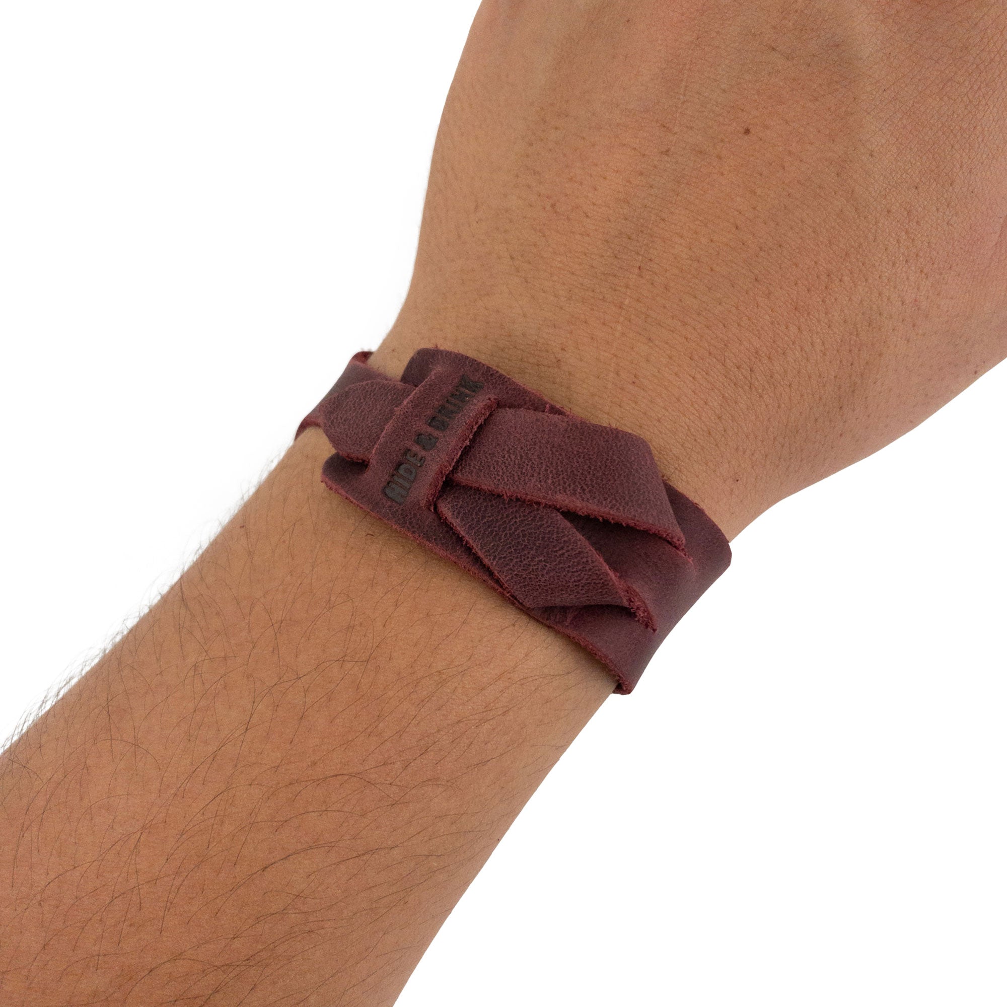 Hide & Drink's Minimalist Wristband worn, showcasing its deep red color and adjustable strap for comfort. Handmade from full grain leather, this stylish cuff embodies the artisan craftsmanship and quality of StockyardX in La Antigua Guatemala.
