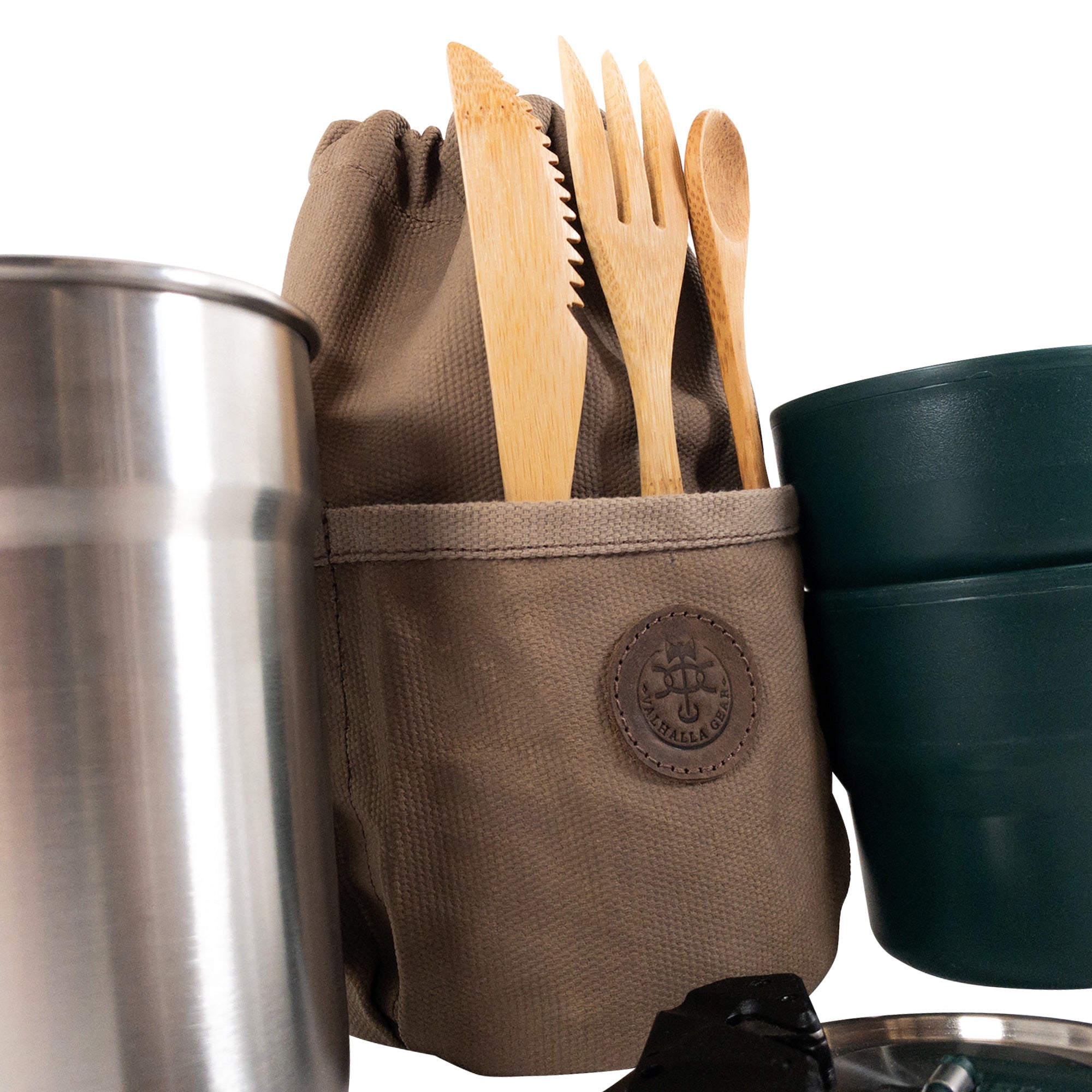 The Valhalla Gear Camping Bag for Water Bottle displayed with utensils and a stainless steel container. The bag highlights its handcrafted quality from waxed canvas and full grain leather, designed for outdoor enthusiasts and handmade in La Antigua Guatemala.