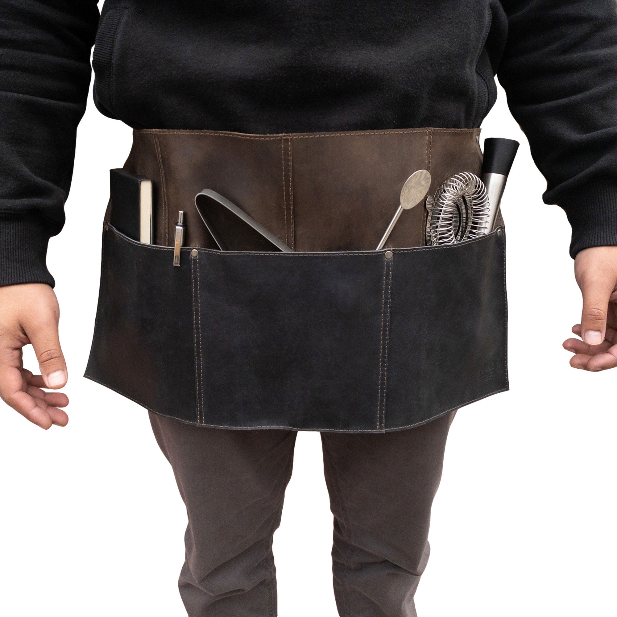 Individual wearing the Hide & Drink Barista Leather Waist Apron, complete with riveted pockets, showcasing its use as waitress and waiter accessories. This full grain leather apron is handmade in La Antigua Guatemala & Oaxaca Mexico.