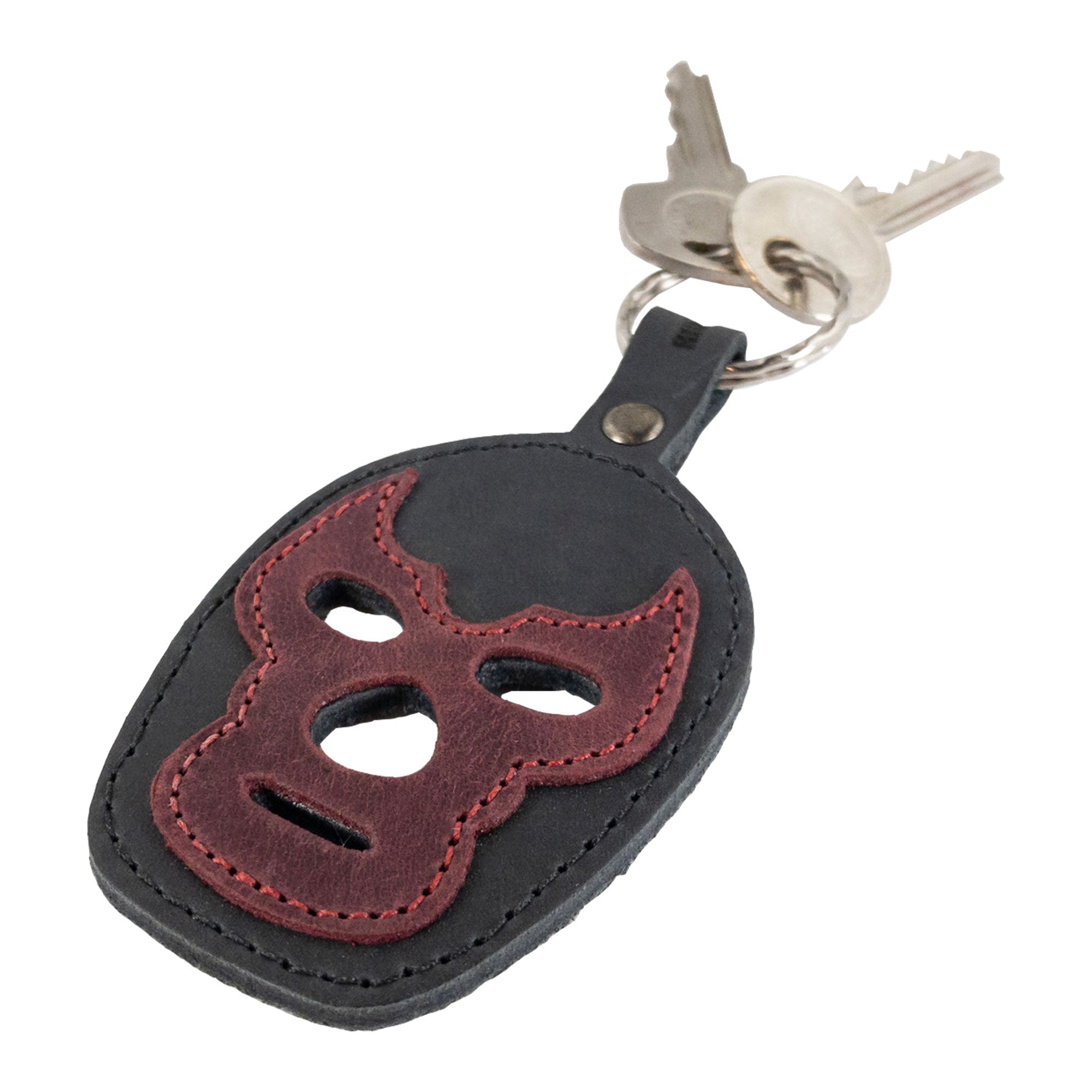 A dark leather Luchador Mask Leather Keychain designed with practicality in mind, shown on a keyring. This key organizer from Hide & Drink combines style with functionality and is crafted from full grain leather, reflecting artisan skills in small batch production, handmade in La Antigua Guatemala and Oaxaca Mexico.