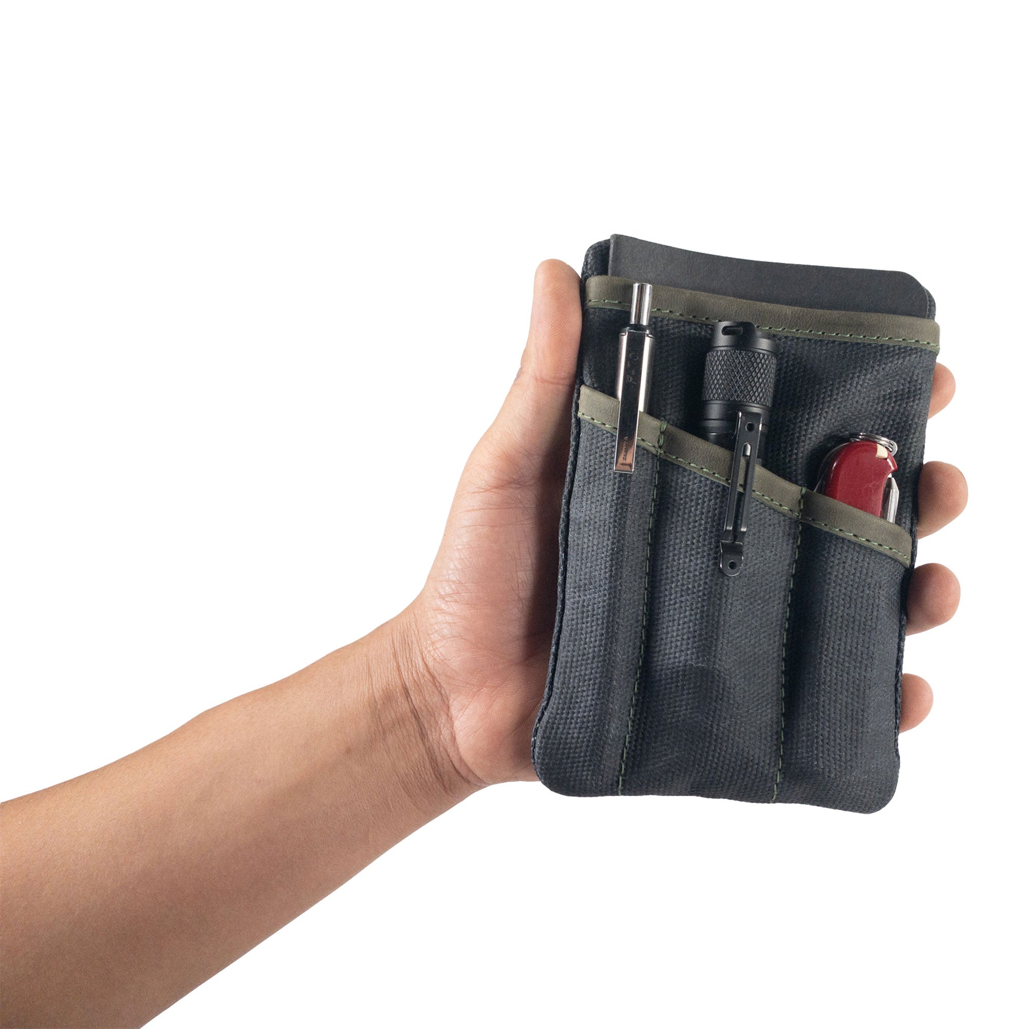 Person holding the navy Multi-tool Pocket Pouch by Hide & Drink, demonstrating its practicality as a compact organizer.