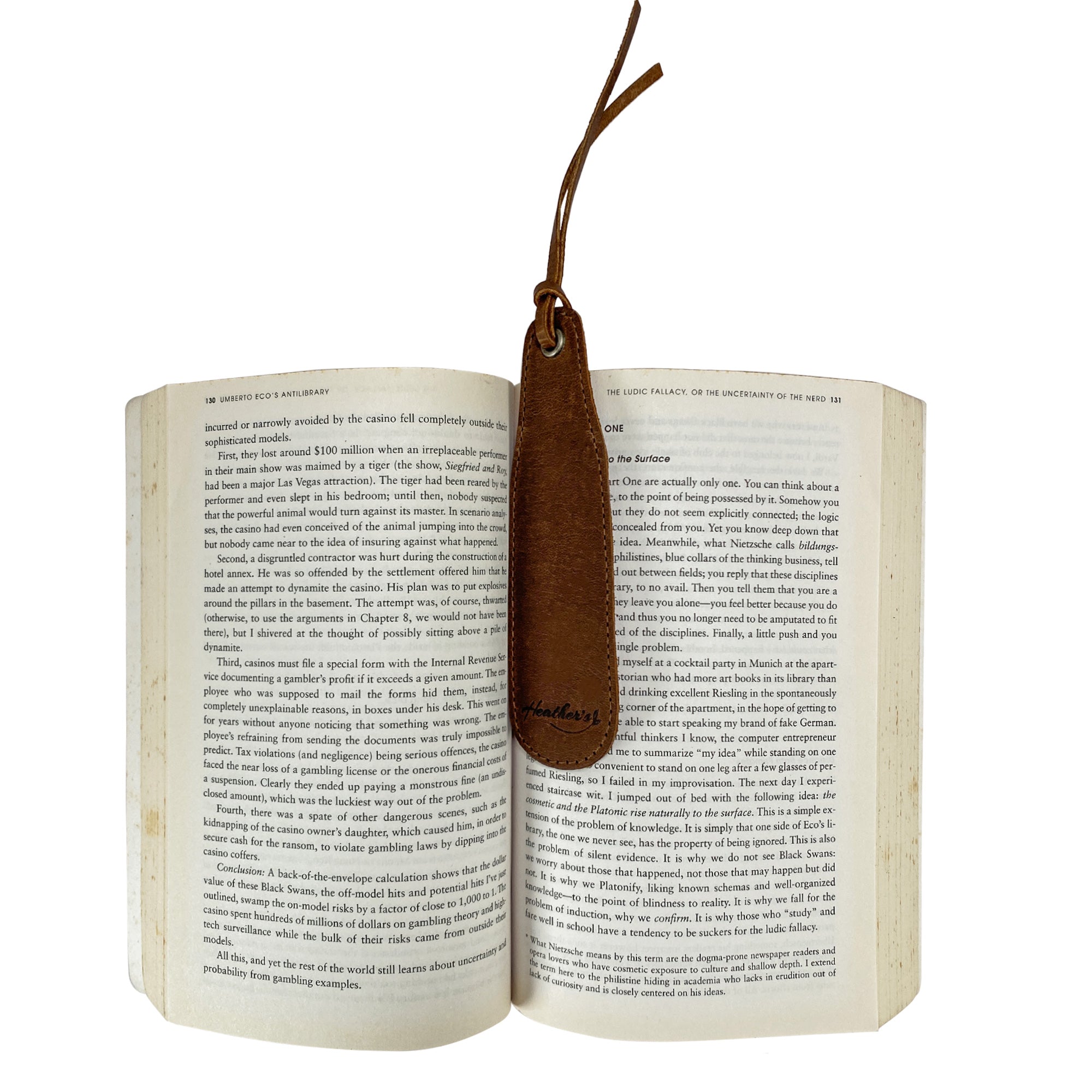 Heather's Bookmark (3 Pack) displaying a full grain leather bookmark in an open book, perfect for avid readers and book lovers. An ideal handcrafted gift for literature fans. Bookmark Page Marker (3 Pack) Book Lovers, Page Turners, Travel Readers, Literature Fans, Book Club Gifts, Full Grain Leather, StockyardX, Small Batch Production, Hand Cut, Hand Sewn, Fire Branded, Artisan, Handmade in La Antigua Guatemala & Oaxaca Mexico.