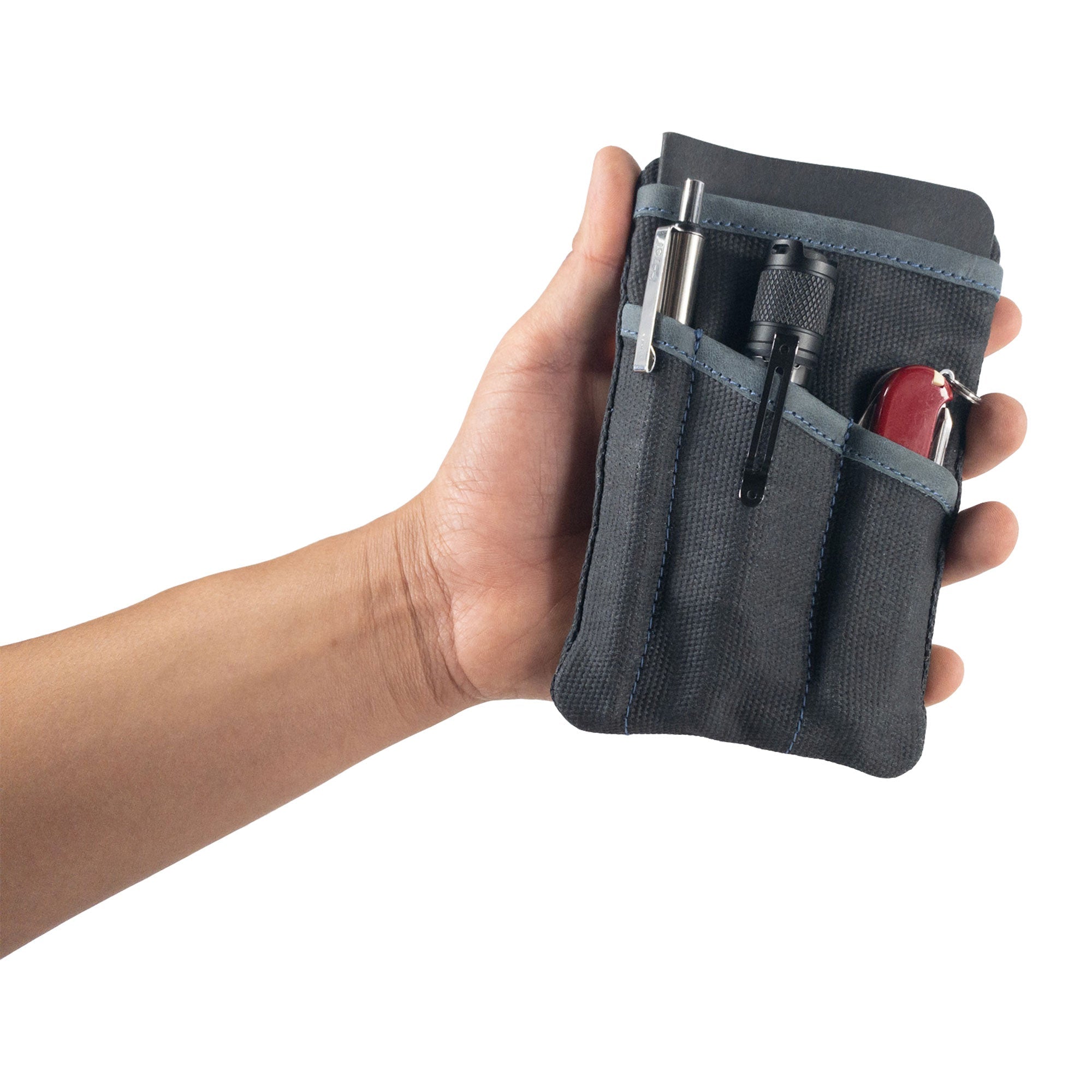 Person holding the dark grey Multi-tool Pocket Pouch by Hide & Drink, showcasing its ergonomic design and craftsman's touch.