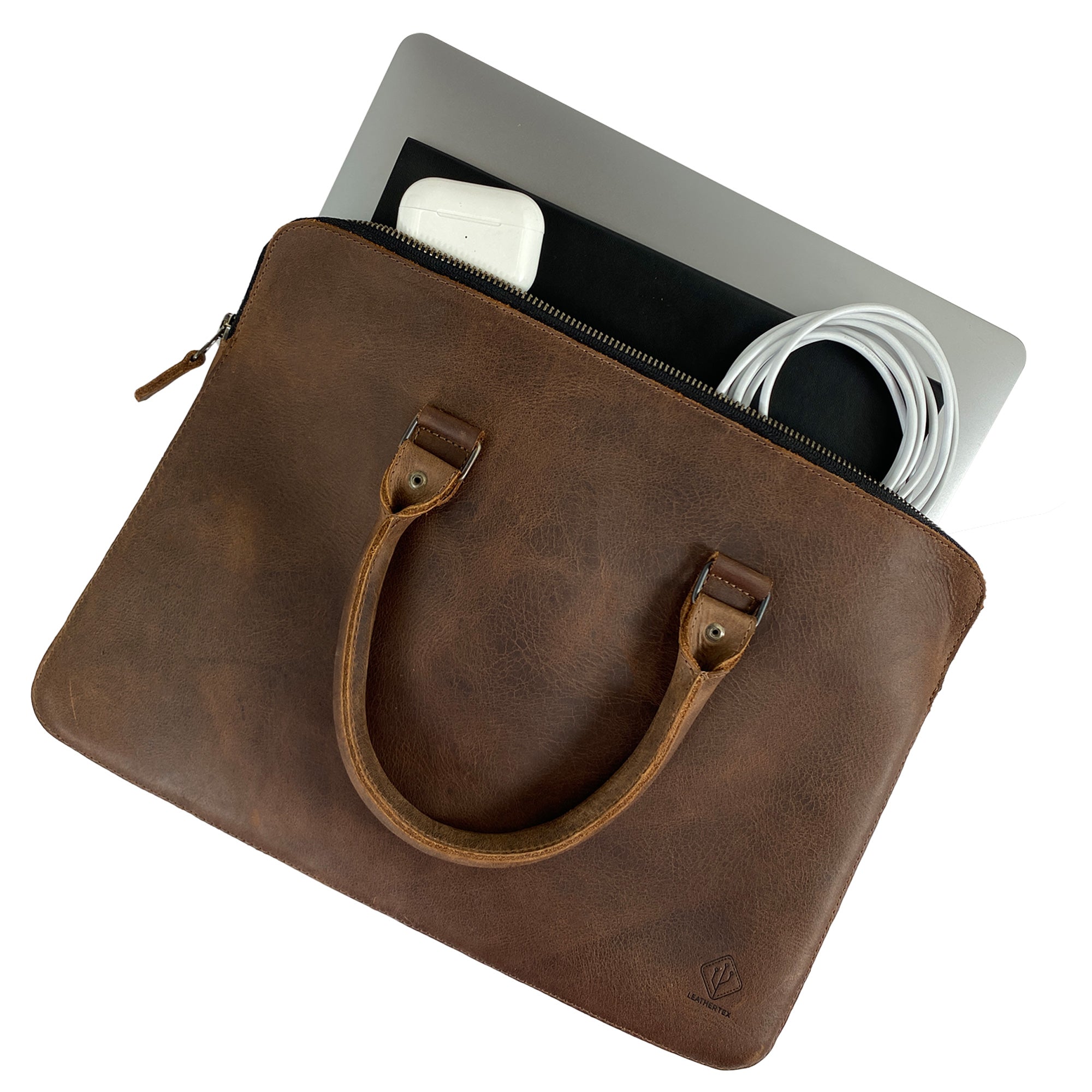 Overhead view of the LeatherTex 13" Laptop Portfolio Case with accessories inside, showcasing its organizational capabilities. This portfolio style case is compatible with MacBook Air/Pro 13 Inch with M1 Chip and is handmade with full grain leather in La Antigua Guatemala and Oaxaca Mexico, emphasizing small batch artisan production.