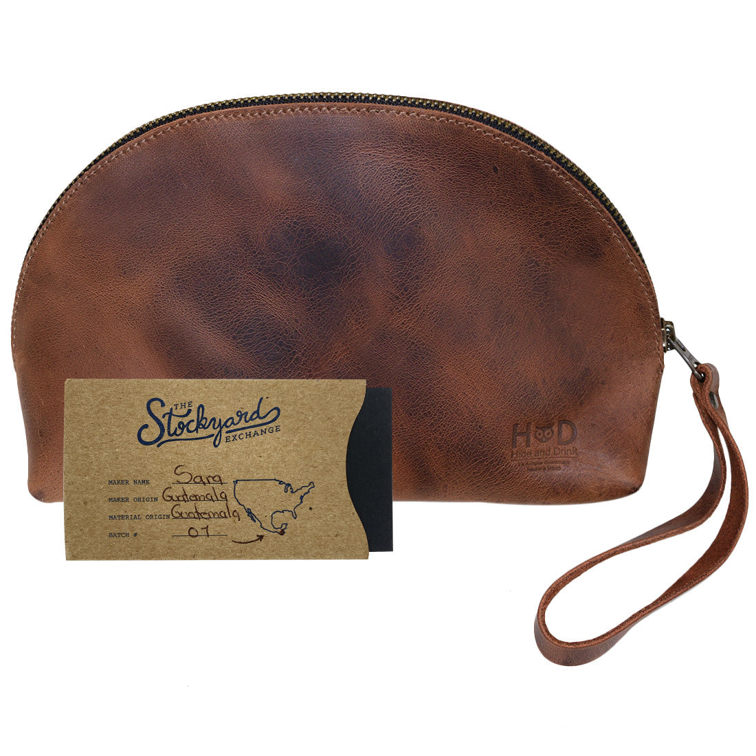 The Accessory Pouch Organizer Hand Bag by Hide & Drink, alongside a business card, highlighting its full grain leather craftsmanship. Ideal as a Cosmetic Travel Organizer with Hand Strap for Women or as a Makeup Bag and Classic Handbag, handcrafted in La Antigua Guatemala & Oaxaca Mexico.