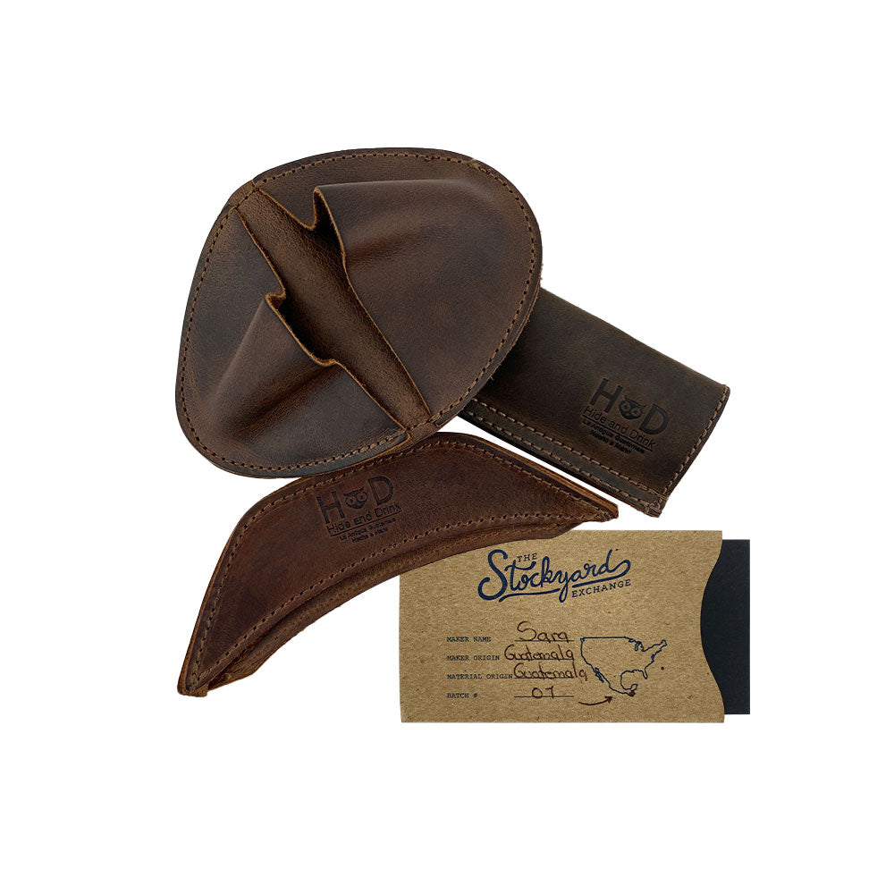 An authentic package of the Hide & Drink Rustic Hot Handle Holders (Set of 3), designed with the Panhandle, Side Kick, and Grip Mitt. This Full Grain Leather set embodies artisanal skills with Small Batch Production, as each item is Hand Cut and Hand Sewn, showcasing craftsmanship from artisans in La Antigua Guatemala & Oaxaca Mexico.