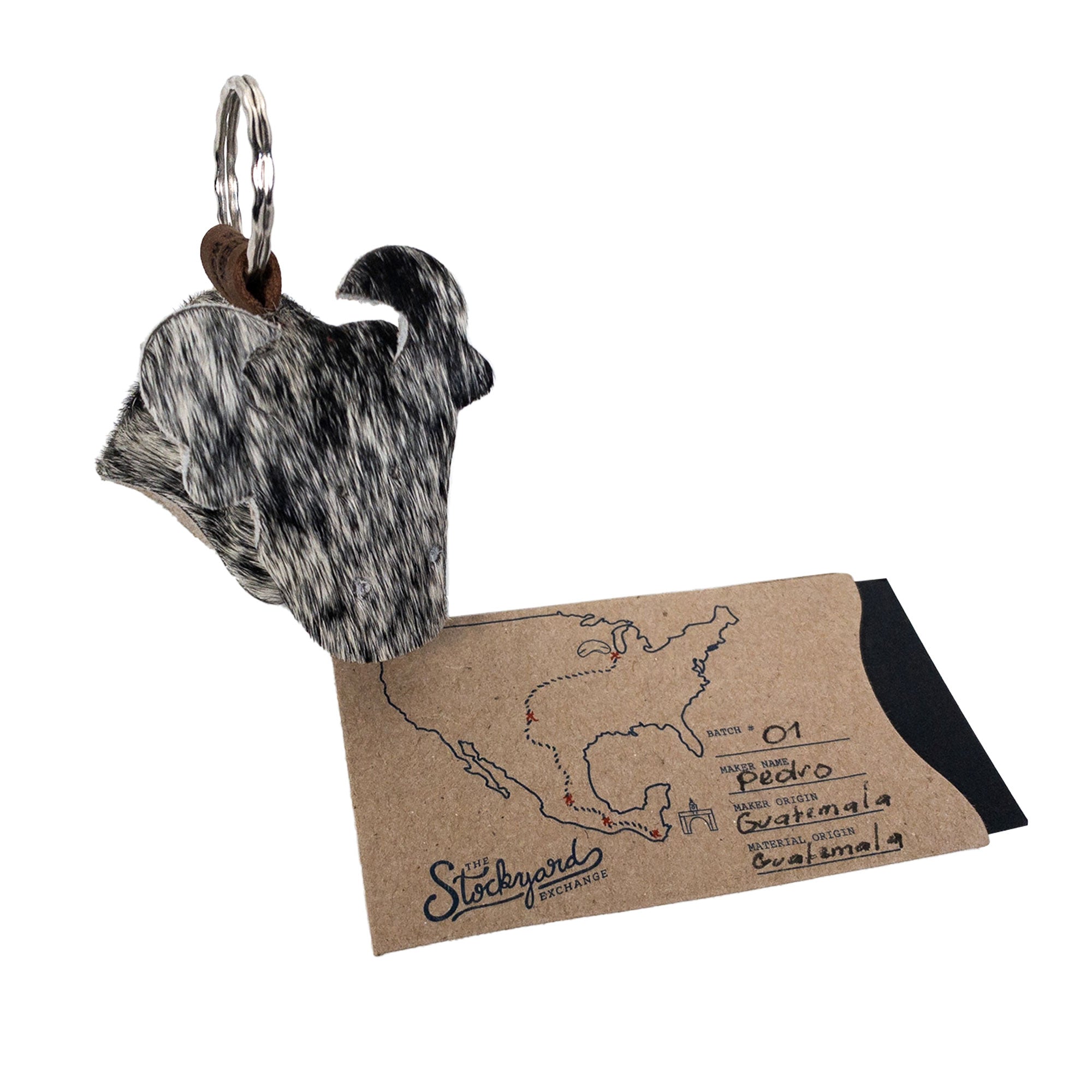 Cow Shape Keychain by Western Leather Works presented alongside a map of origins. Crafted from Hair-On-Hide Full Grain Leather, this piece represents small batch production with hand cut and hand sewn elements, showcasing the dedication to artisan craftsmanship from La Antigua Guatemala and Oaxaca Mexico.