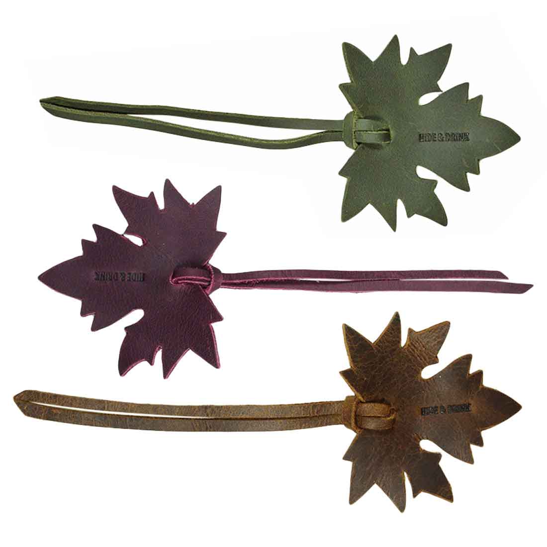 A detailed view of the Autumn Bookmark (3 pack) by Hide & Drink, featuring a set of three leather bookmarks, each shaped like a maple leaf. These handcrafted bookmarks are great for book lovers and perfect as gifts, exemplifying the quality of full grain leather. Autumn Bookmark (3 Pack), Bookworm Gifts, Cute Accessories, Small Batch Production, Hand Cut, Hand Sewn.