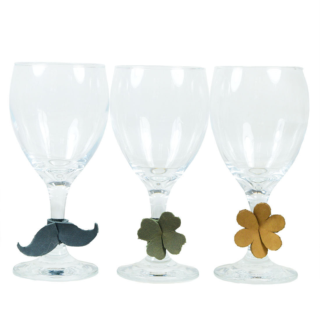 Drink Tags (6 Pieces) by Hide & Drink showcasing three leather wine glass tags in the shapes of mustaches, flowers, and leaves, perfect for identifying drinks at gatherings. These Drink Markers also function as elegant napkin rings, adding a touch of class to any event. Crafted from Full Grain Leather using small batch production, all tags are handmade by local artisans in La Antigua Guatemala & Oaxaca Mexico.