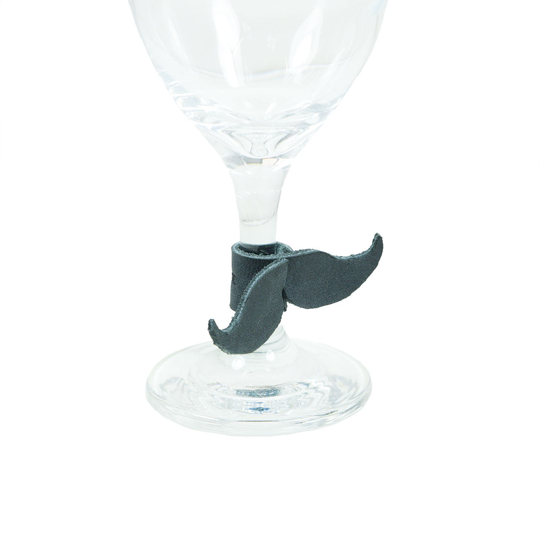 Close-up of a gray leather mustache Drink Tag (6 Pieces) by Hide & Drink used as a unique wine glass marker. This stylish accessory helps guests easily identify their drinks while doubling as a playful napkin ring. Crafted from Full Grain Leather, these hand cut and hand sewn items reflect the small batch production quality from artisans in La Antigua Guatemala & Oaxaca Mexico.