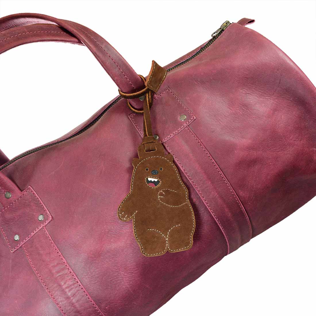 Bear Luggage Tag from Hide & Drink attached to a stylish bag. This playful suitcase identifier and baggage label is crafted from durable full grain leather. A must-have travel essential showcasing small batch production and artisan craftsmanship, hand cut and hand sewn, made in La Antigua Guatemala & Oaxaca Mexico.